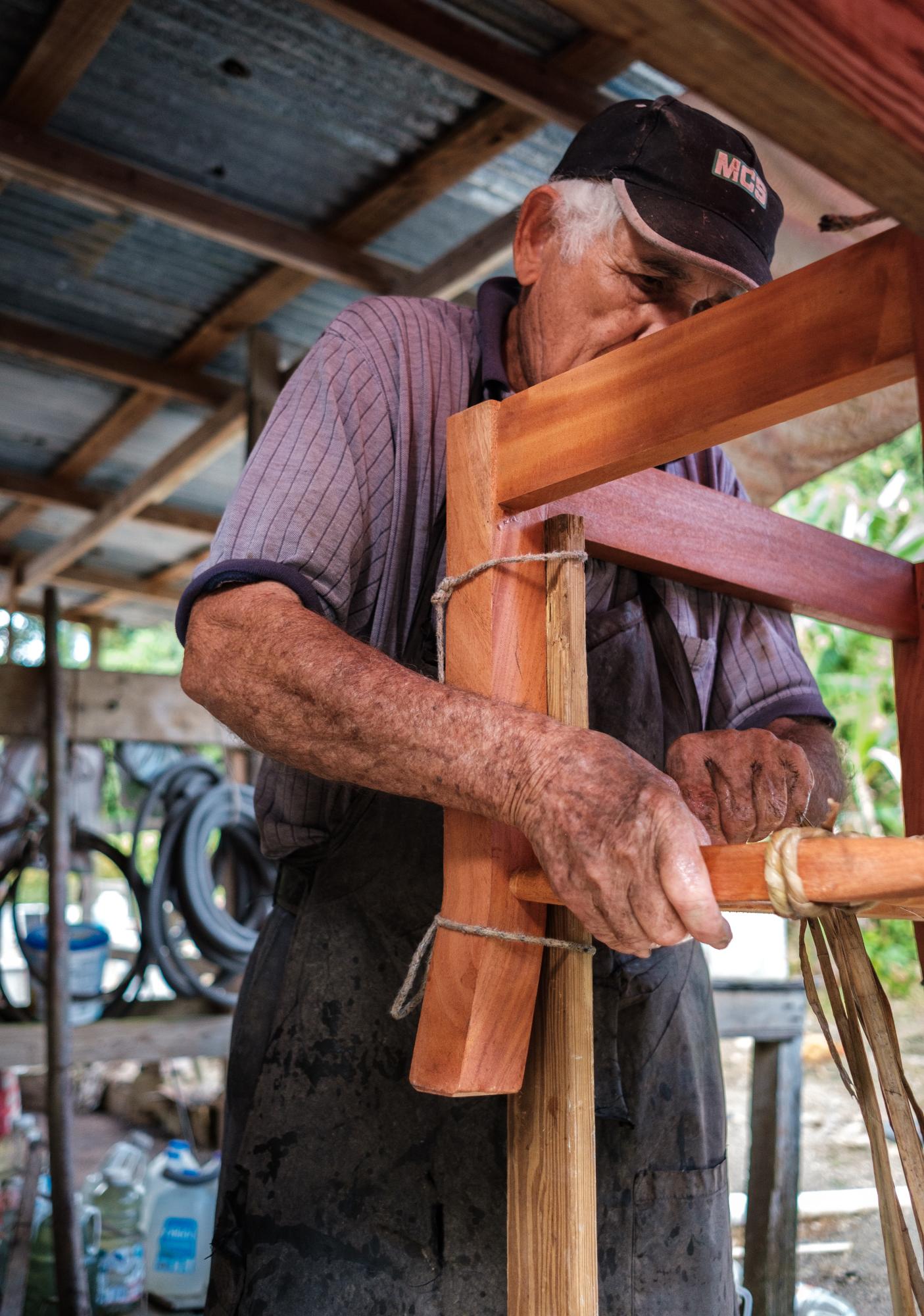 Survived by Few - Smithsonian Magazine Cover Story - Miguel Cruz, a relative of the Villalobos family prepares a J&iacute;baro chair for weaving,...