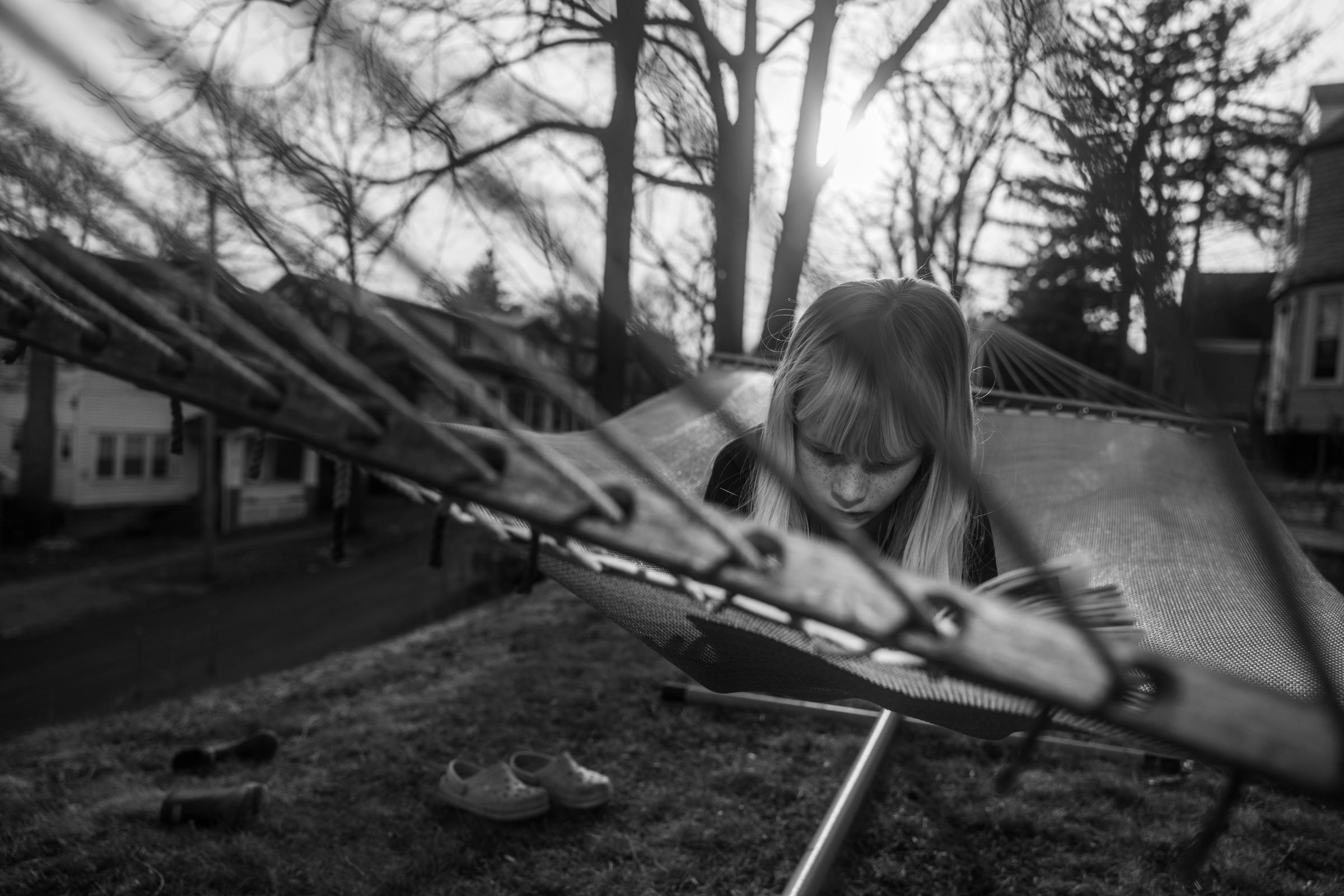 Family is Everything - Ella lays on her cousins' hammock and reads one of her...