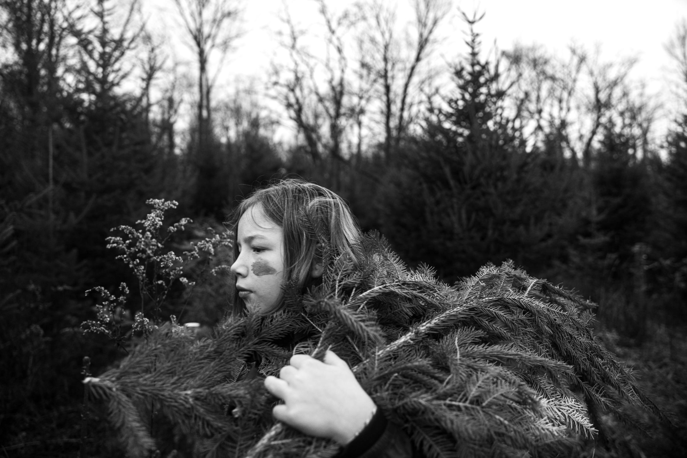 Liesl carries branches back to the car that she's found on the ground to use for handmade reeths in Syracuse, New York on December 11, 2021....