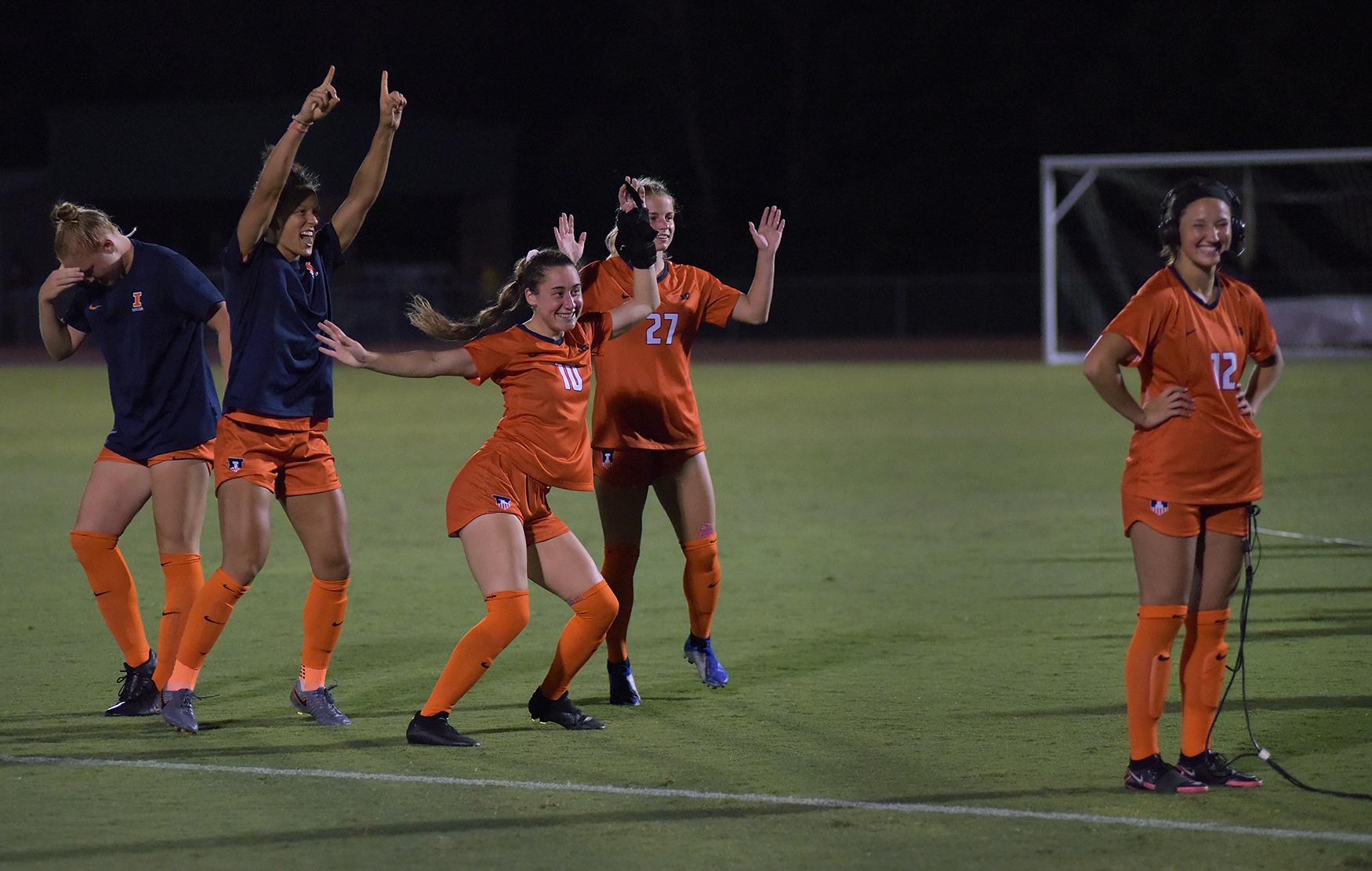 Home - Illinois players dance behind Kendra Pasquale, far right,...