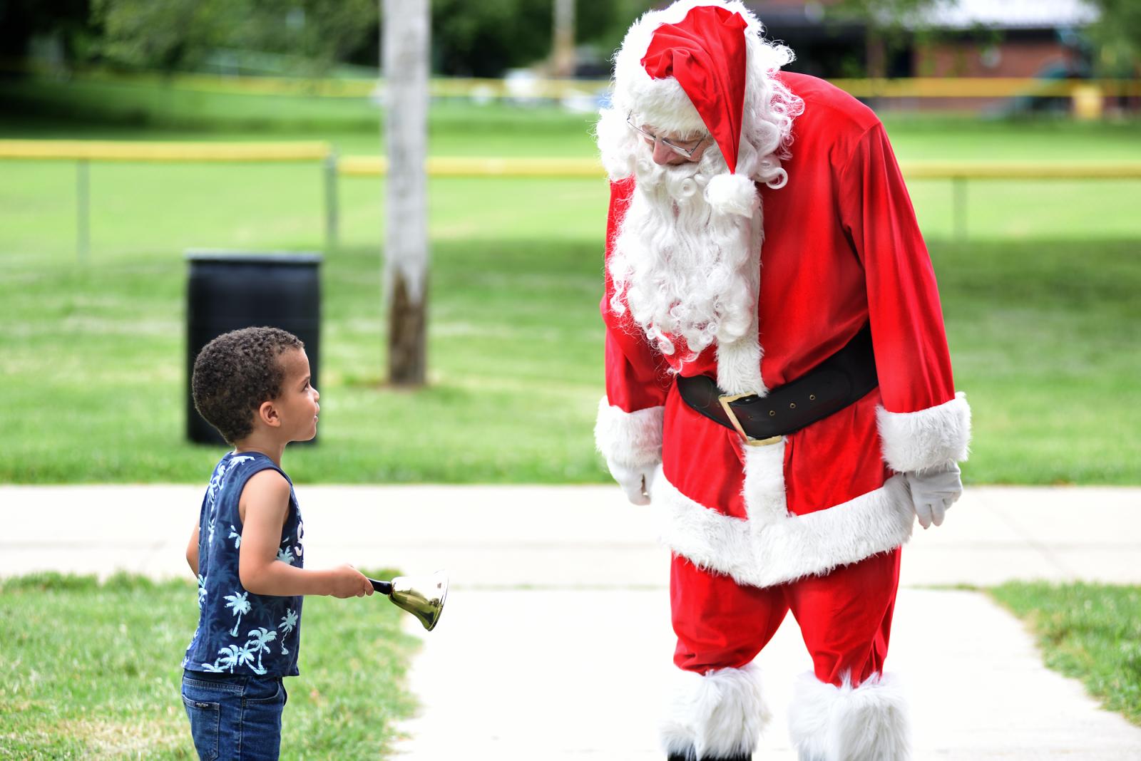Kephas O., 4, rings a bell given to him by Santa Claus on Thursday, July 15, 2021 at Douglass Park in Columbia. Santa delivered presents to kids that attended the Christmas in July party hosted by the Voluntary Action Center.