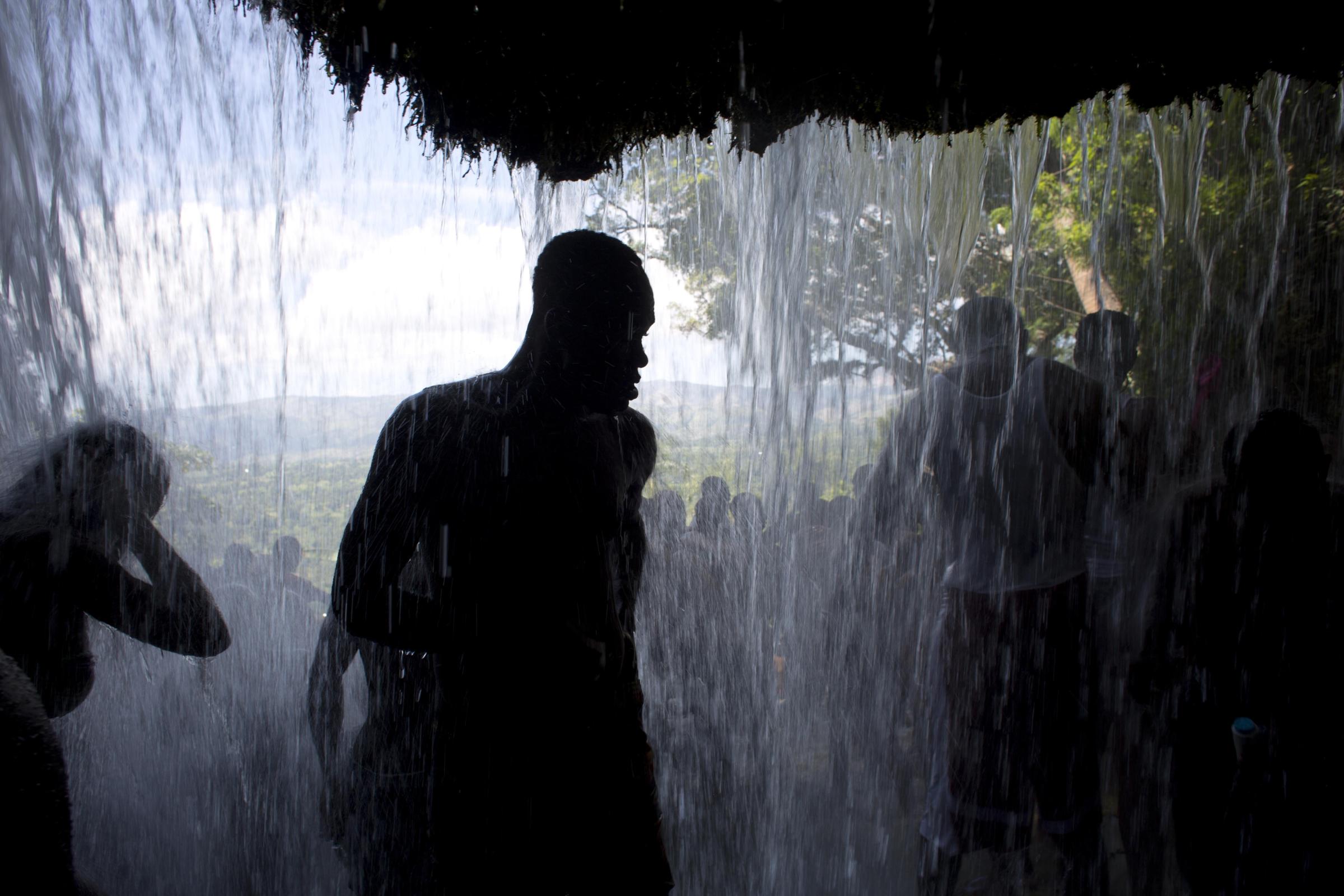 Vodou in Haiti - Voodoo pilgrims bathe in a waterfall believed to have...