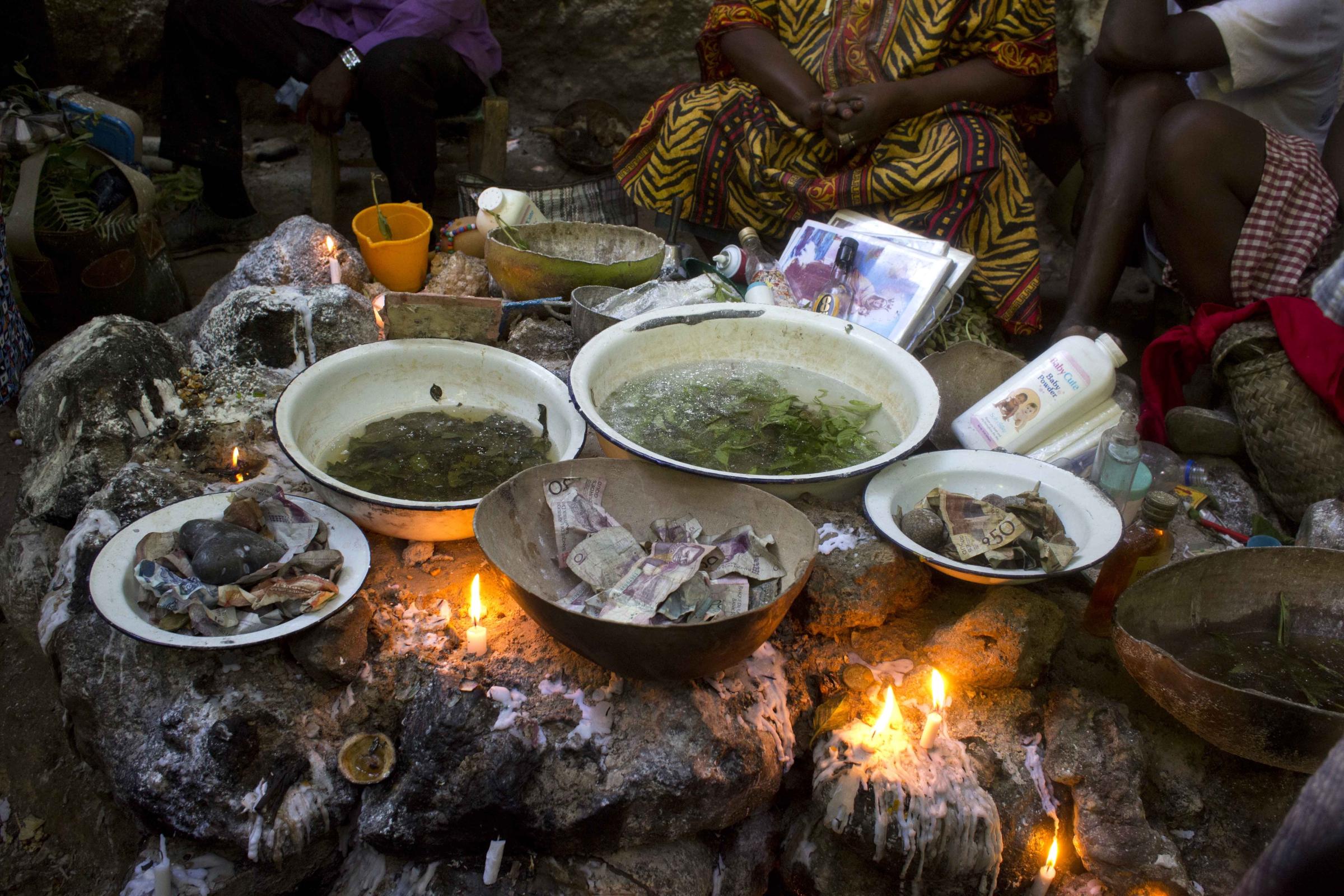 Vodou in Haiti - Voodoo pilgrims heat aromatic leaves before bathing in a...