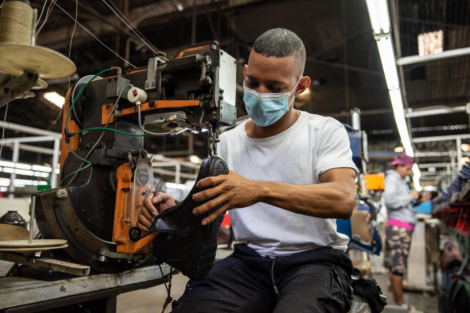 A worker stitches the sole of a...grapher: Jair F. Coll/Bloomberg