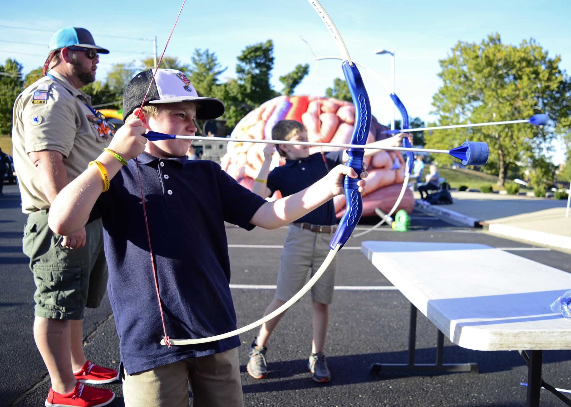 Community  - Gannon Hite, 9, aims to shoot a play bow with his twin...