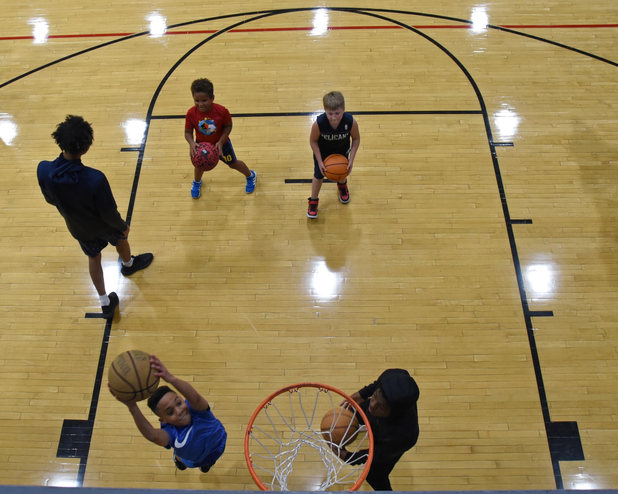 Community  - Chrystian Happy, 12, makes a shot as Micah Wood, 7, left,...