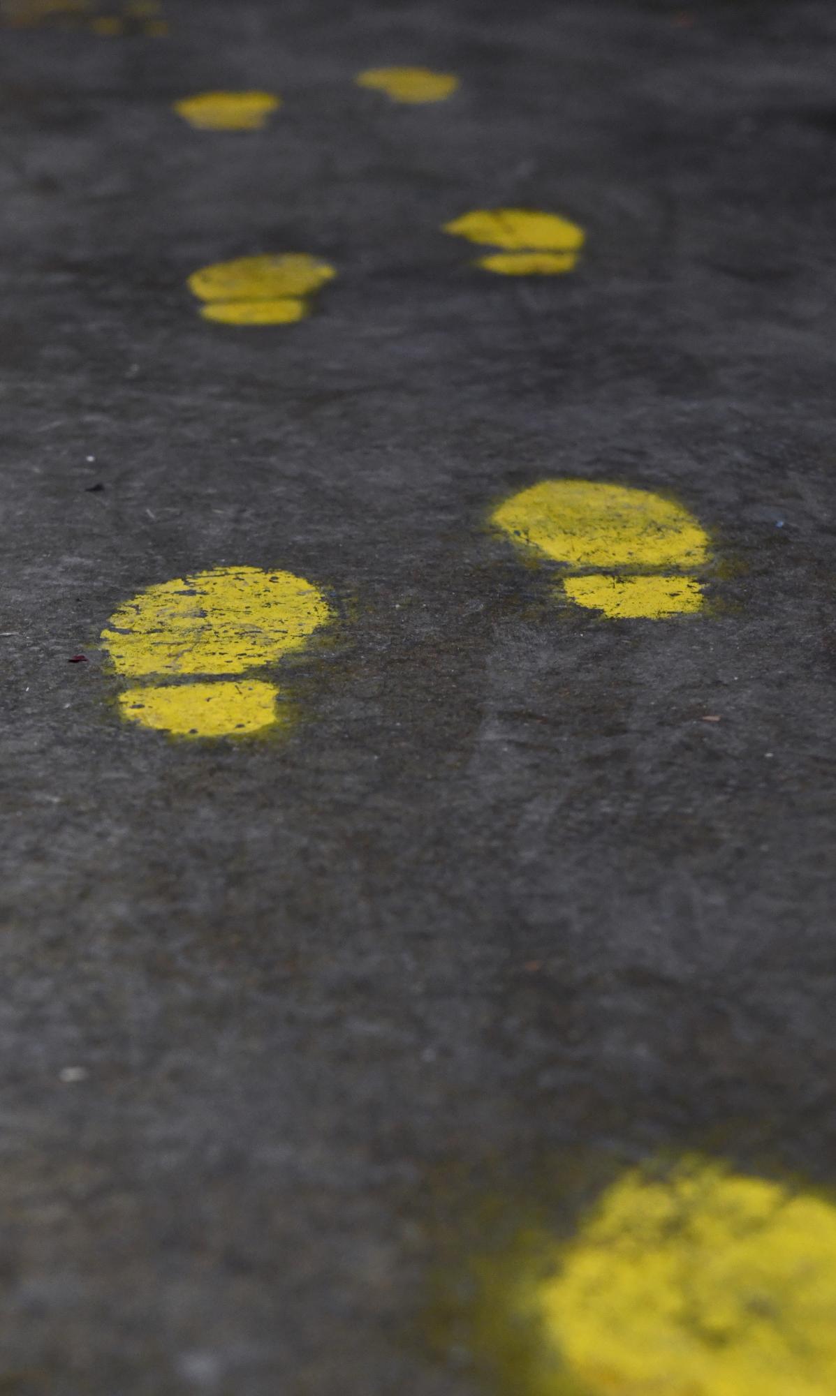 Hickman IGA: Serving community since 1959 - Yellow-painted footprints line the back of the grocery...