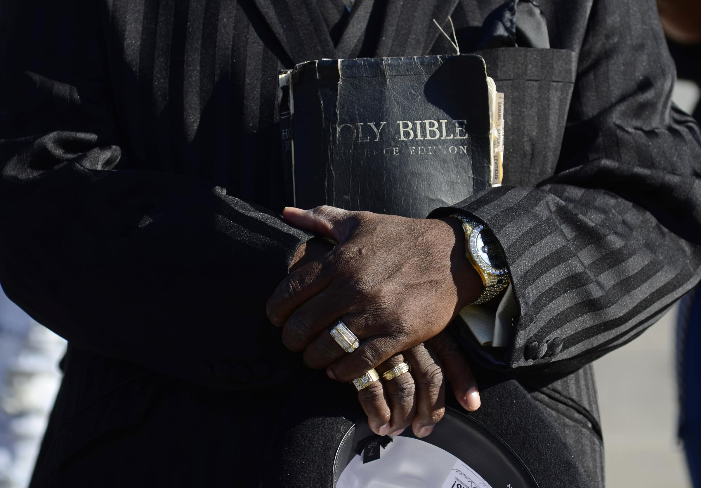 Community  - Pastor Fennis Brown cradles a bible on Wednesday, Nov. 9,...