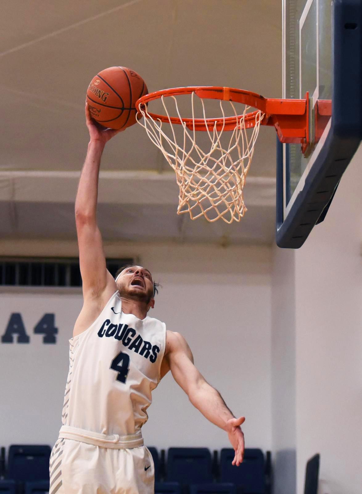 Community  - Columbia College’s Cole Gerken goes up to dunk...