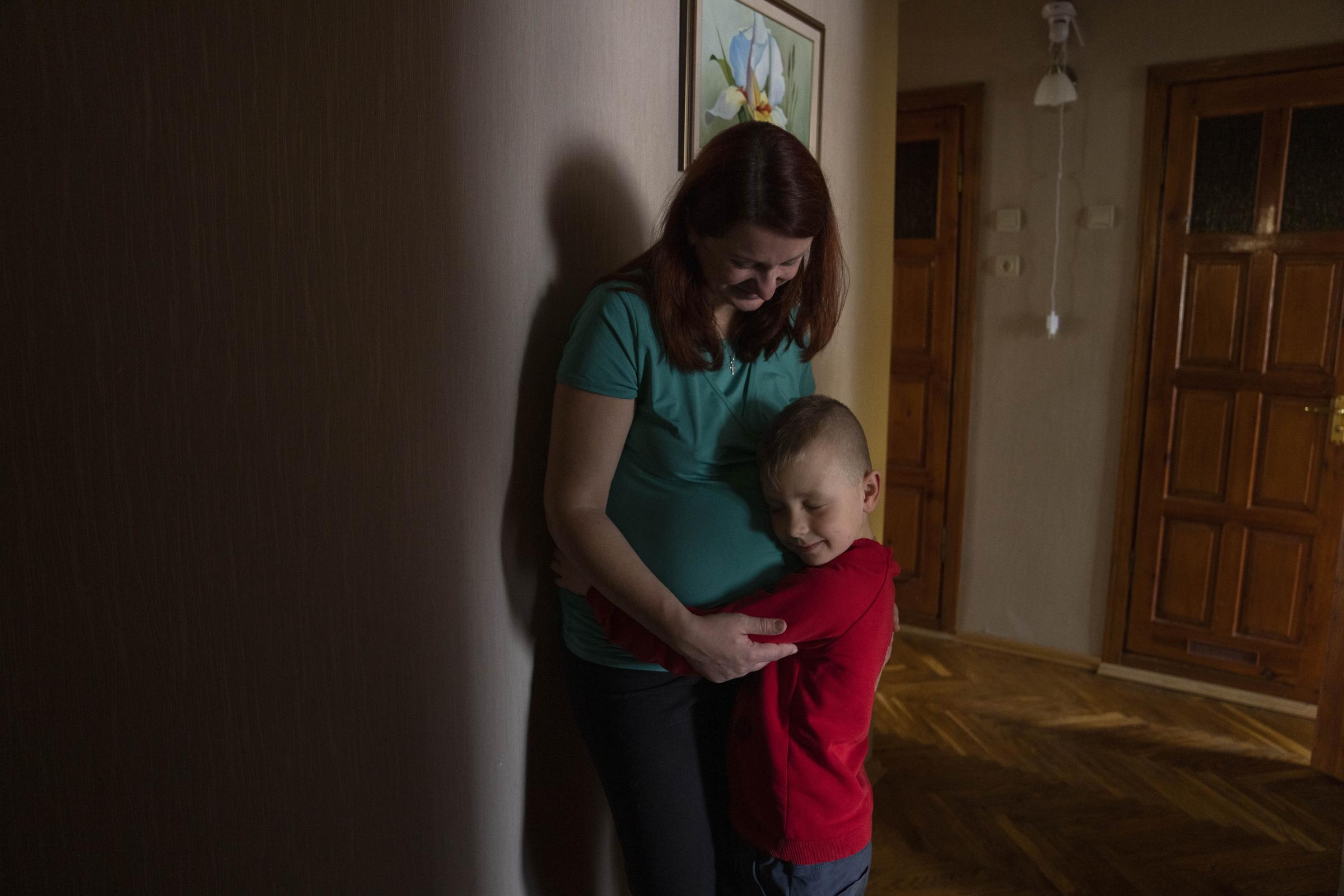 Marta, 38-weeks pregnant, holds her 6-year-old son Nazar, at an apartment given to them by a cousin after fleeing their home in Kyiv.