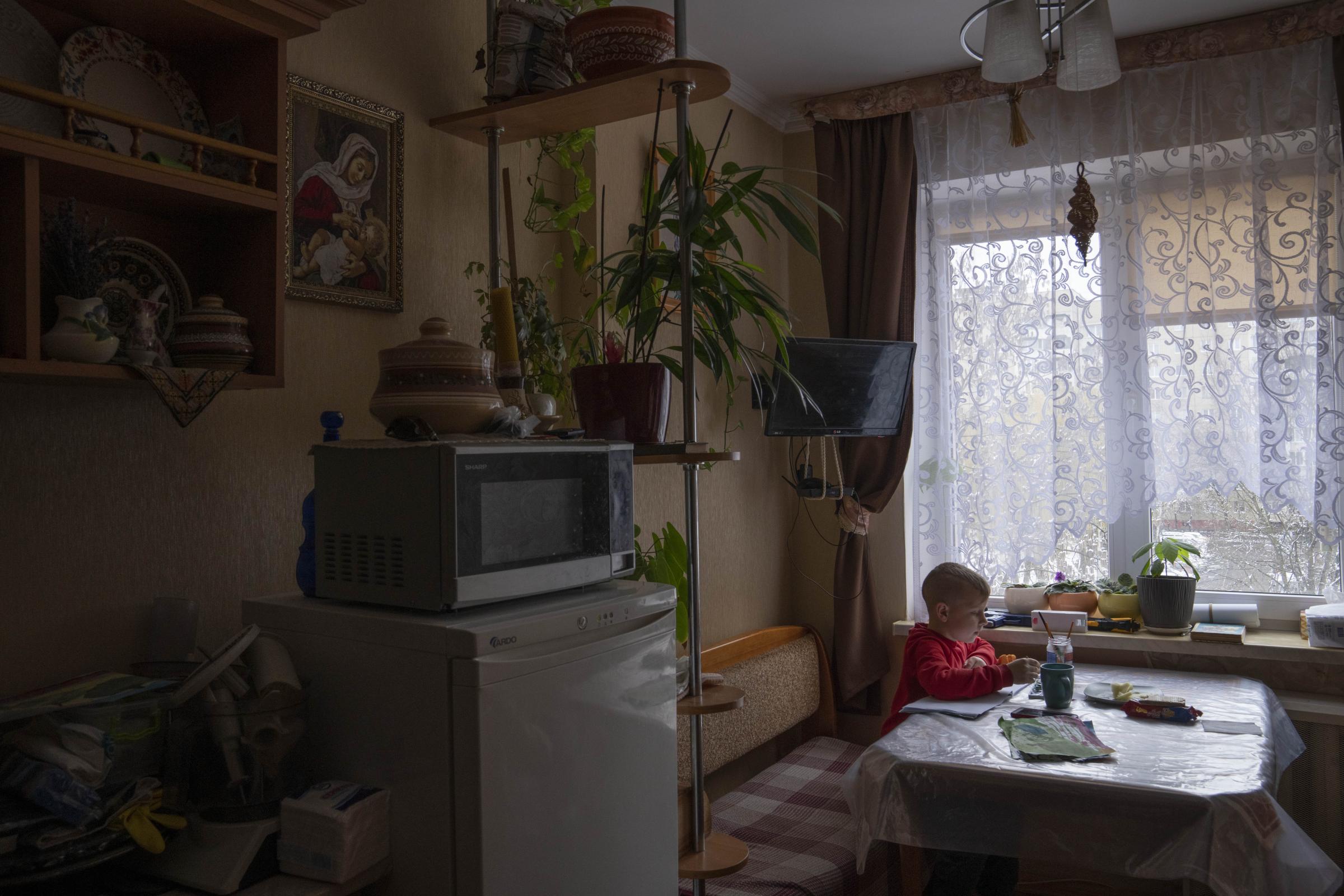Nazar, paints in the kitchen of an apartment given to his family by a cousin after they fled their home in Kyiv.