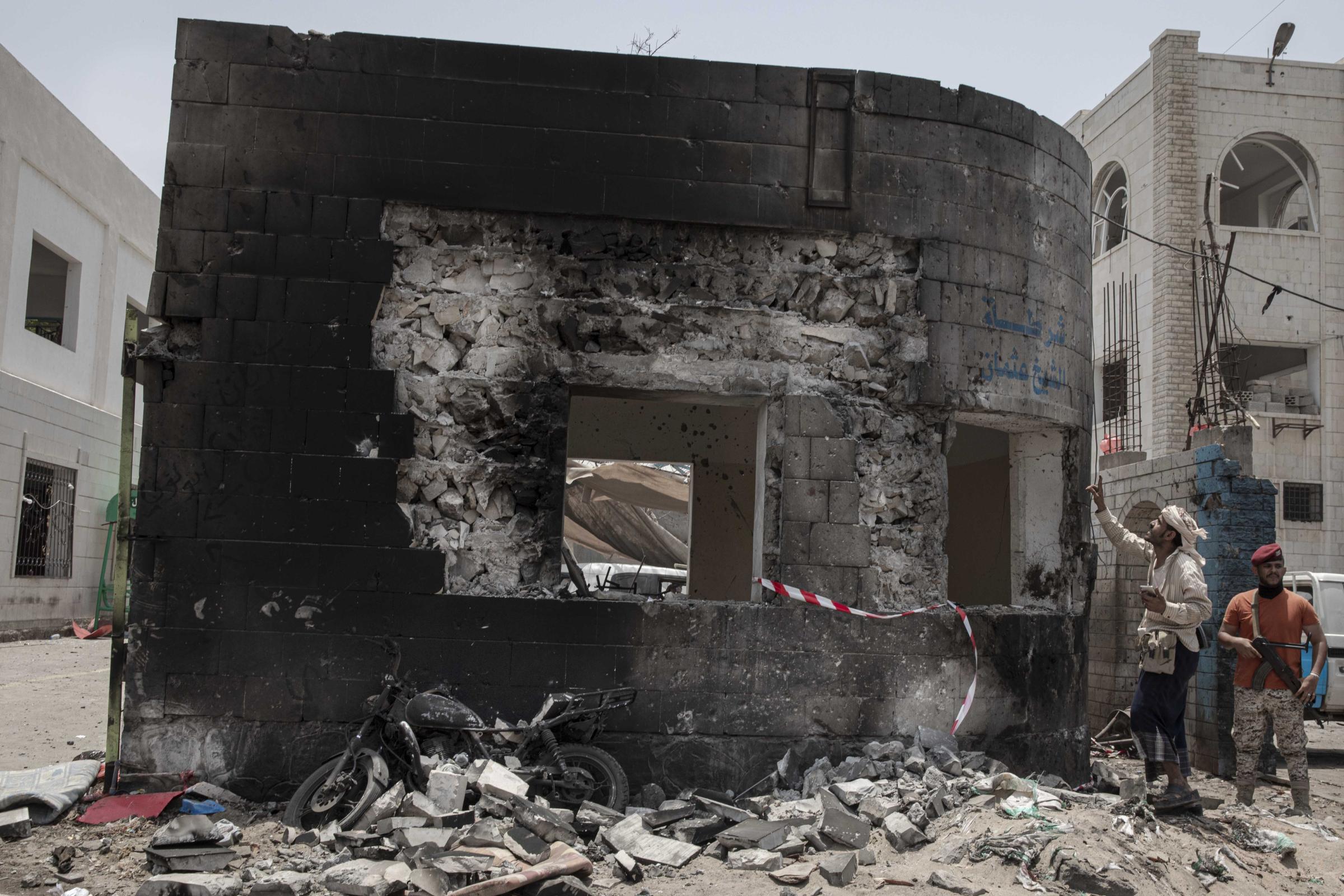  Security forces inspect the site of a deadly attack inside the Sheikh Othman police station in Aden. 