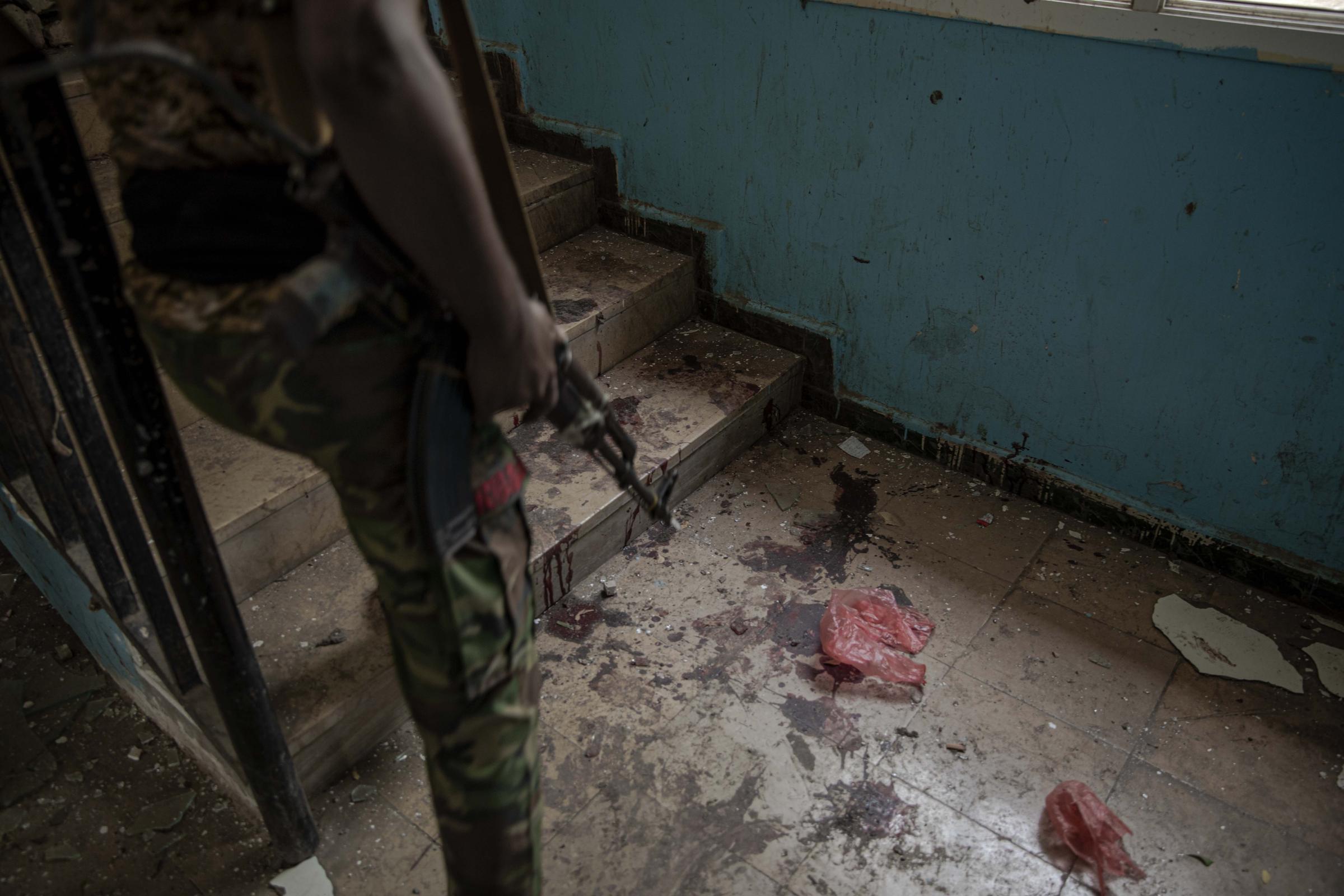  A solider walks past blood after a deadly attack on the Sheikh Othman police station. 