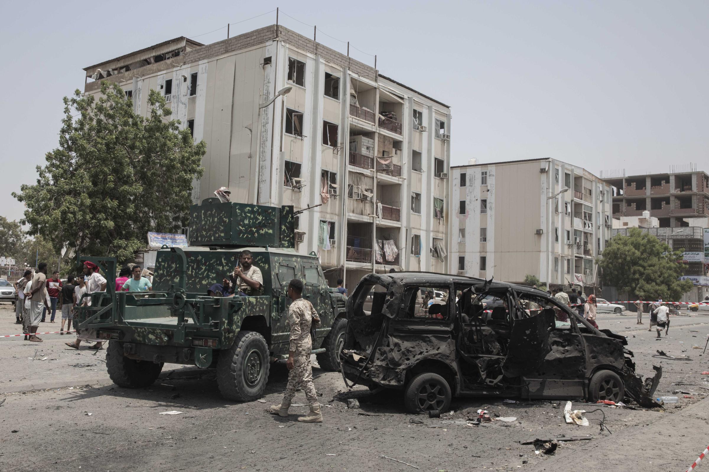  Civilians and security forces gather at the site of a deadly attack. 