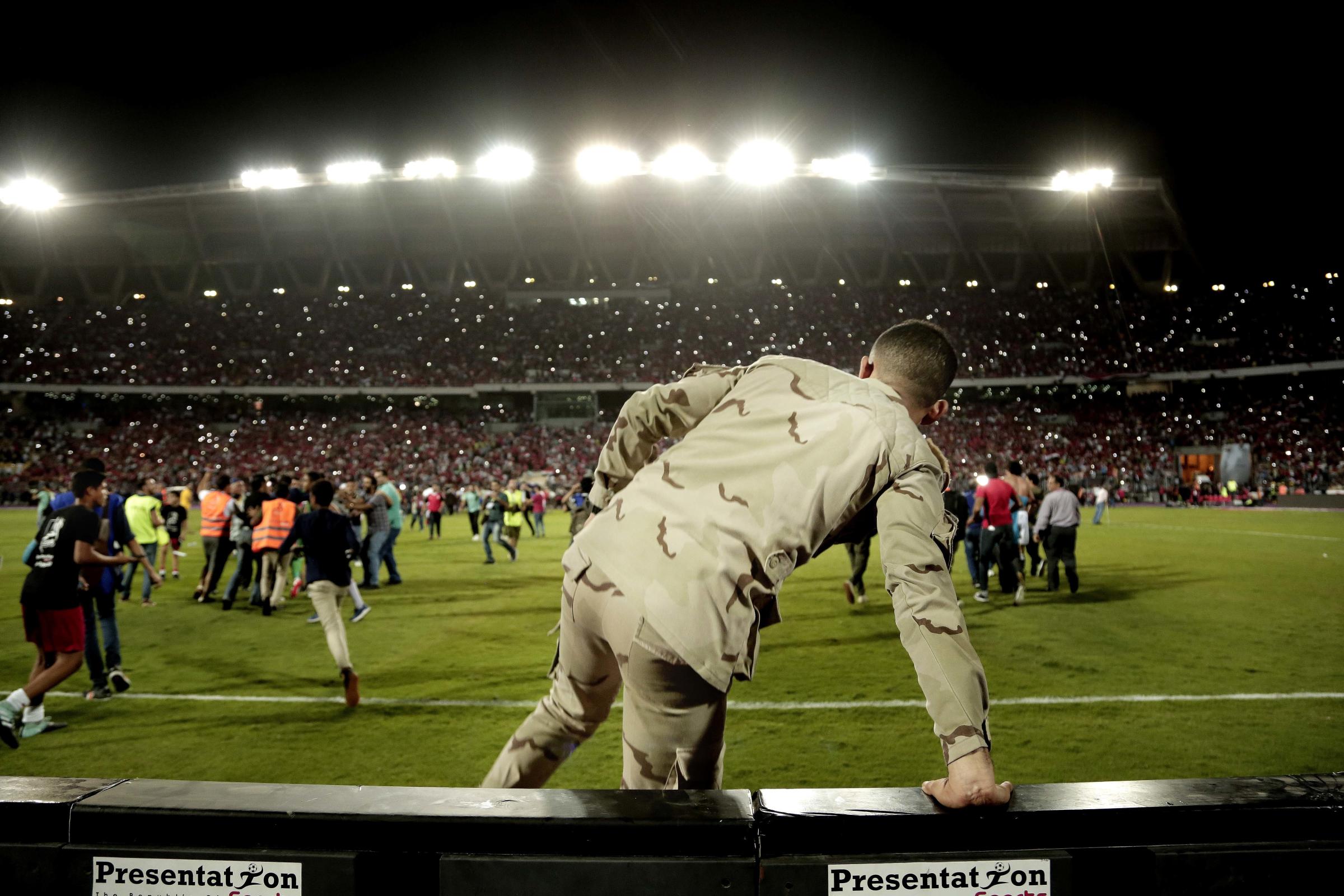  An Egyptian army solider runs to Salah and his teammates for protection, as fans try to take photographs with the team, after defeating Congo. 