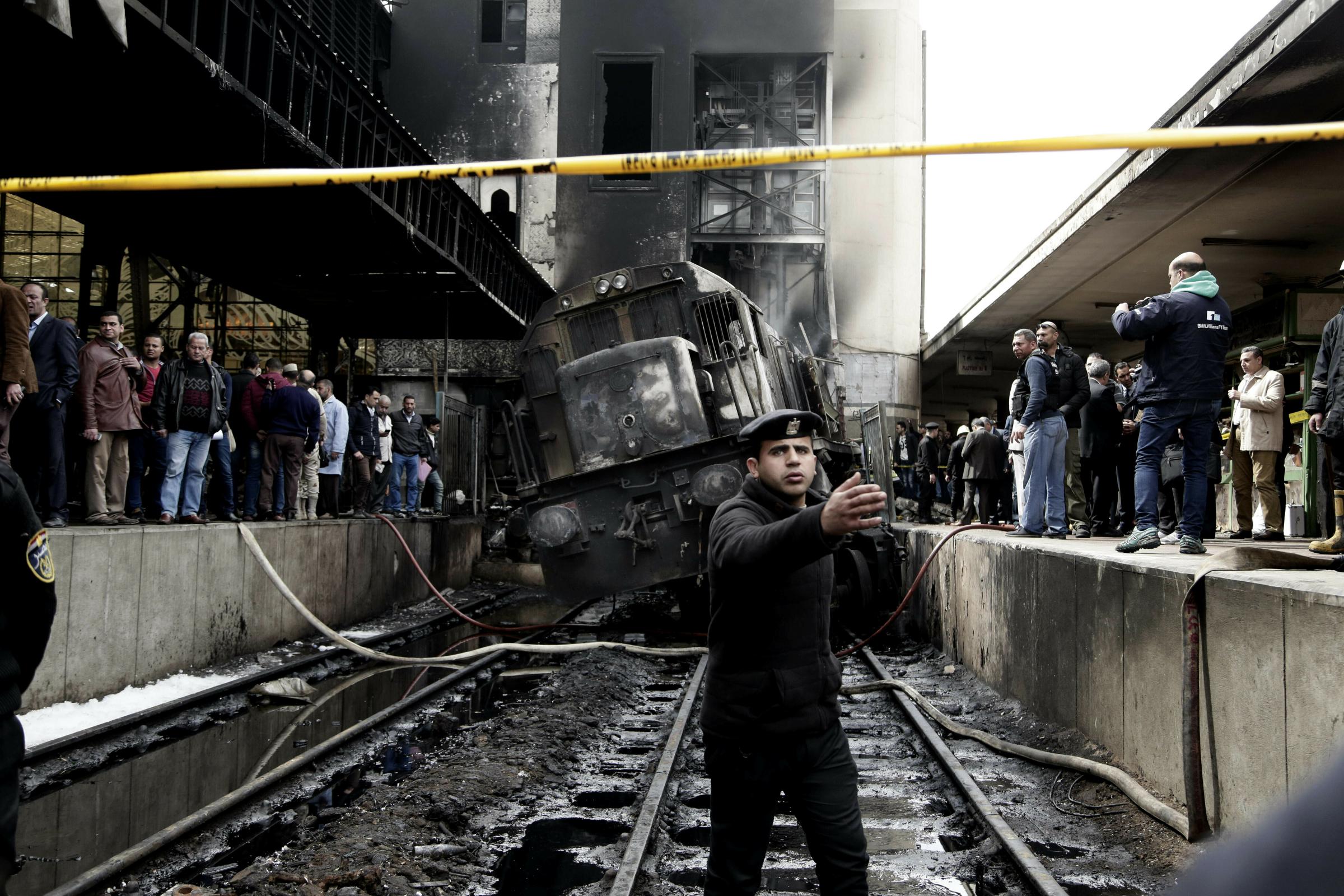 Policemen stand guard in front of a damaged train inside Ramsis train station in Cairo on Feb. 27, 2019. An Egyptian medical official said at least 20 people have been killed and dozens injured after a railcar rammed into a barrier inside the station causing an explosion of the fuel tank and triggering a huge blaze that engulfed that part of the station. 