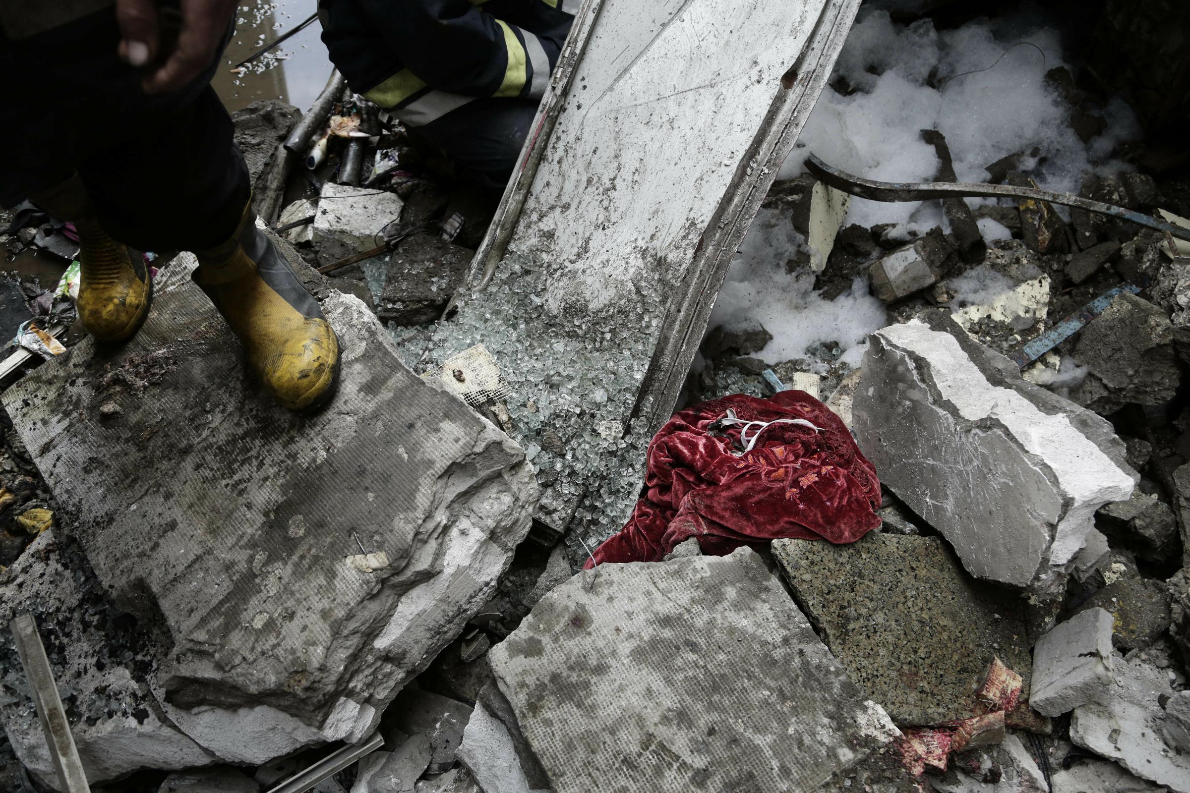  A firefighter stands amid rubble and blood-stained clothes after a train crash inside Ramsis train station. 