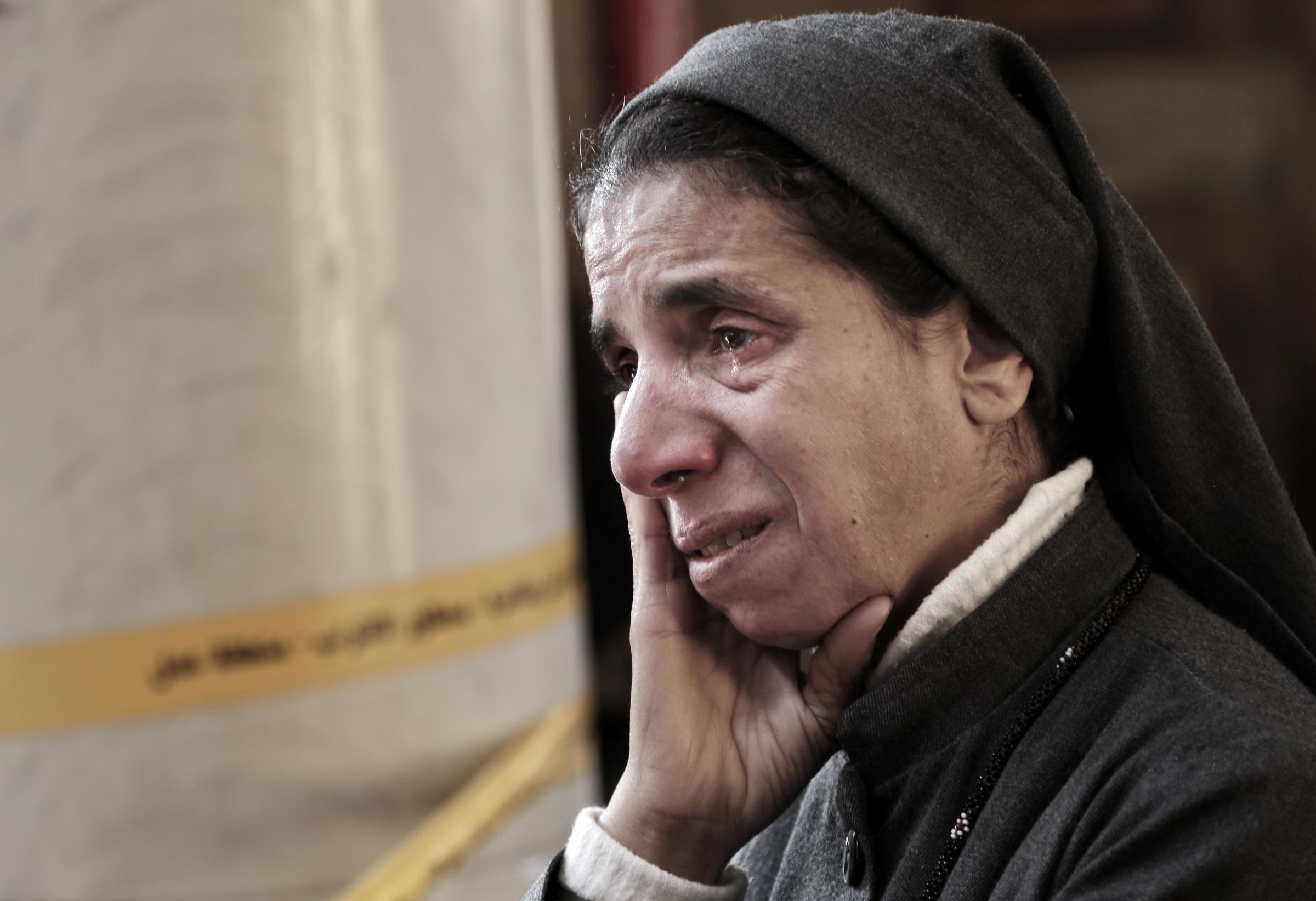 Egypt's main Coptic Christian cathedral attack -  A Coptic nun weeps as she looks at damages inside the...