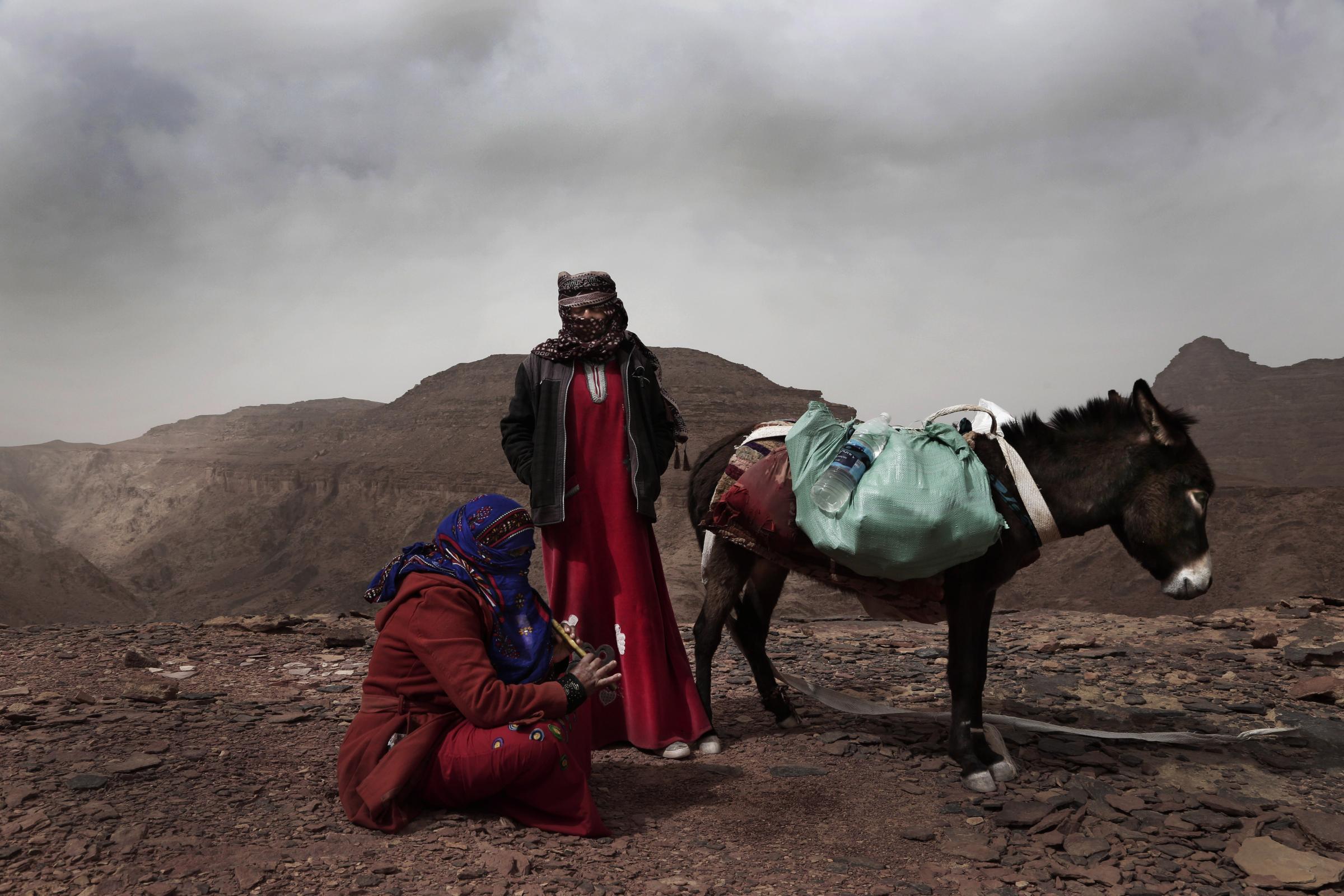 Umm Yasser, the first Bedouin female guide from the Hamada tribe, looks at Umm Soliman as she plays the flute, near Wadi Sahw, Abu Zenima, in South Sinai, Egypt on March 2019. Umm Yasser is breaking new ground among the deeply conservative Bedouin of Egypt&rsquo;s Sinai Peninsula. Women among the Bedouin almost never work outside the home, and even more rarely do they interact with outsiders. But Umm Yasser is one of four women from the community who for the first time are working as tour guides.