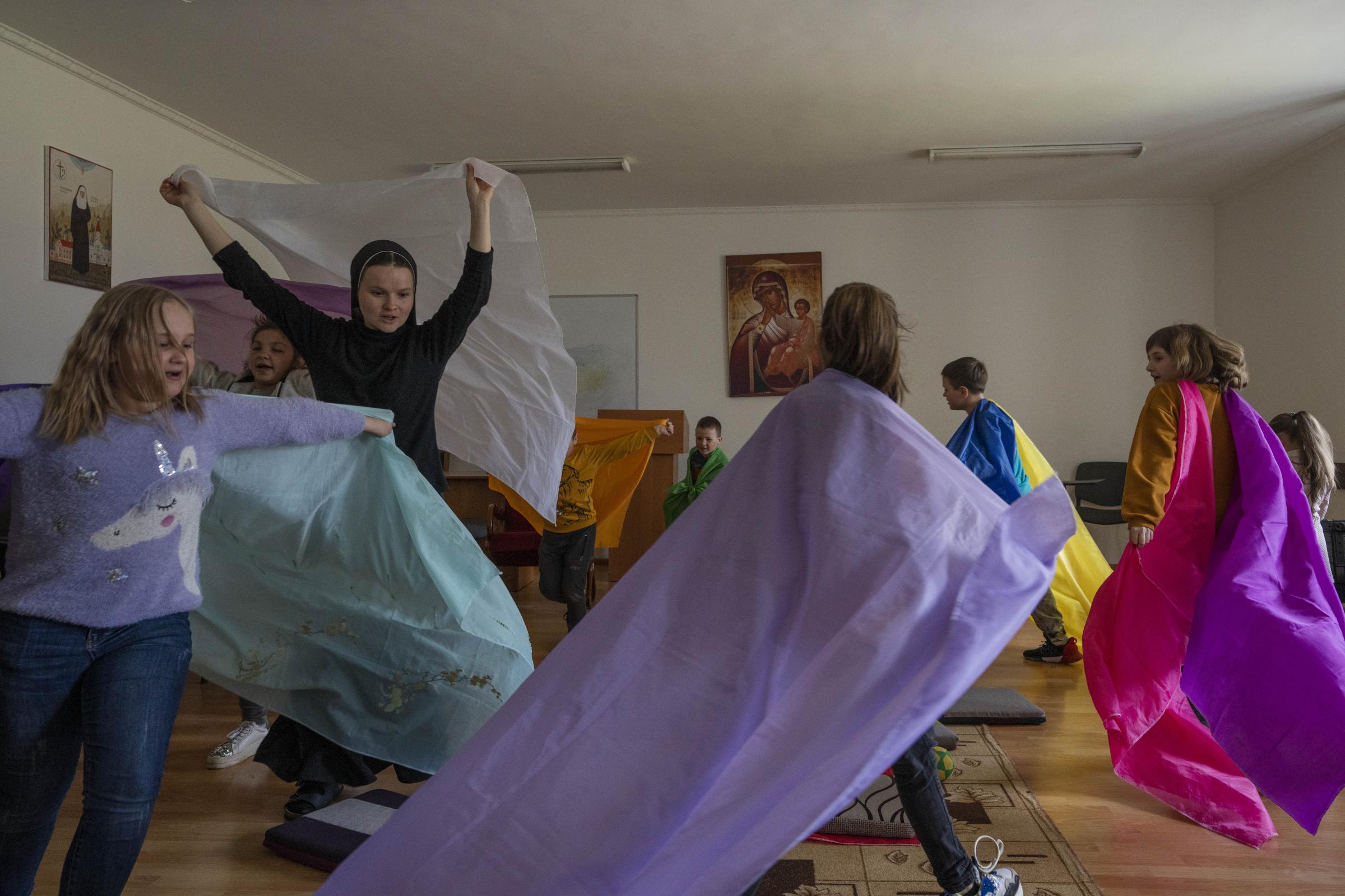 Ukraine's nuns open monastery doors to the displaced - Nuns play with internally displaced children.