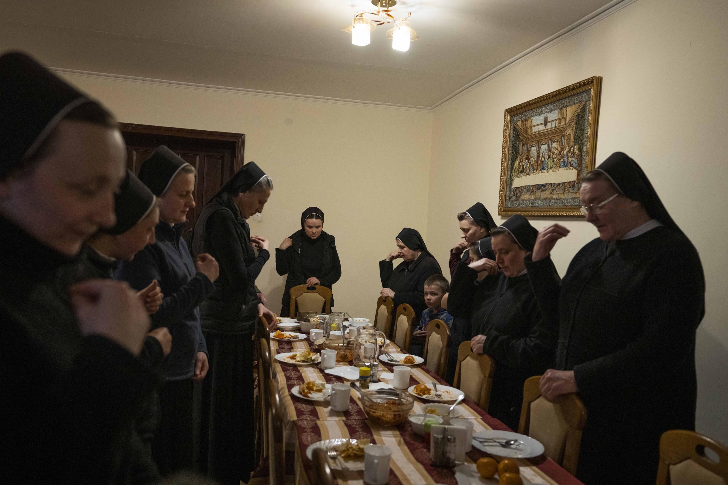 Ukraine's nuns open monastery doors to the displaced - Nuns make prayers after eating dinner.