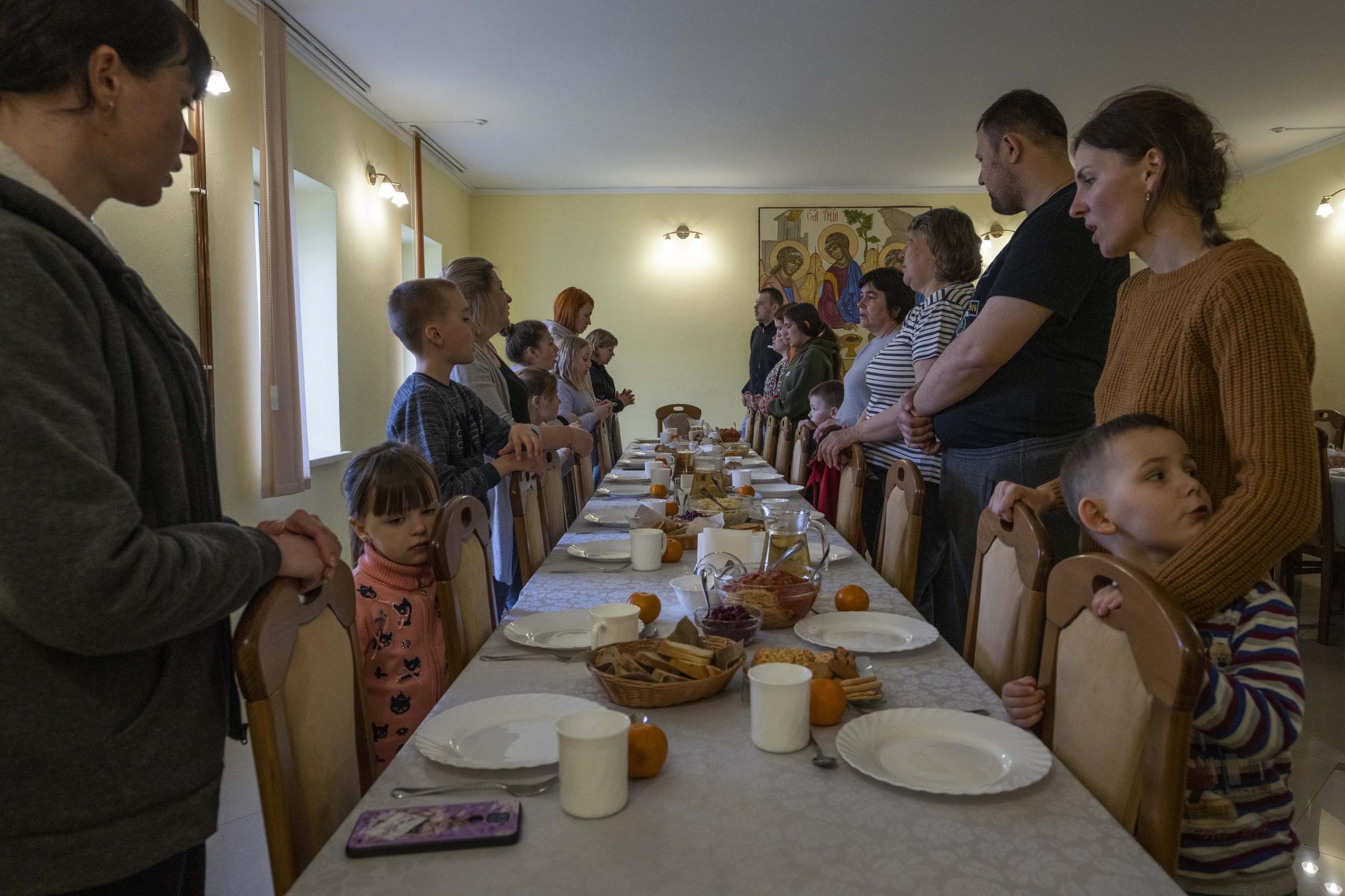 Ukraine's nuns open monastery doors to the displaced - Internally displaced families make prayers before dinner.