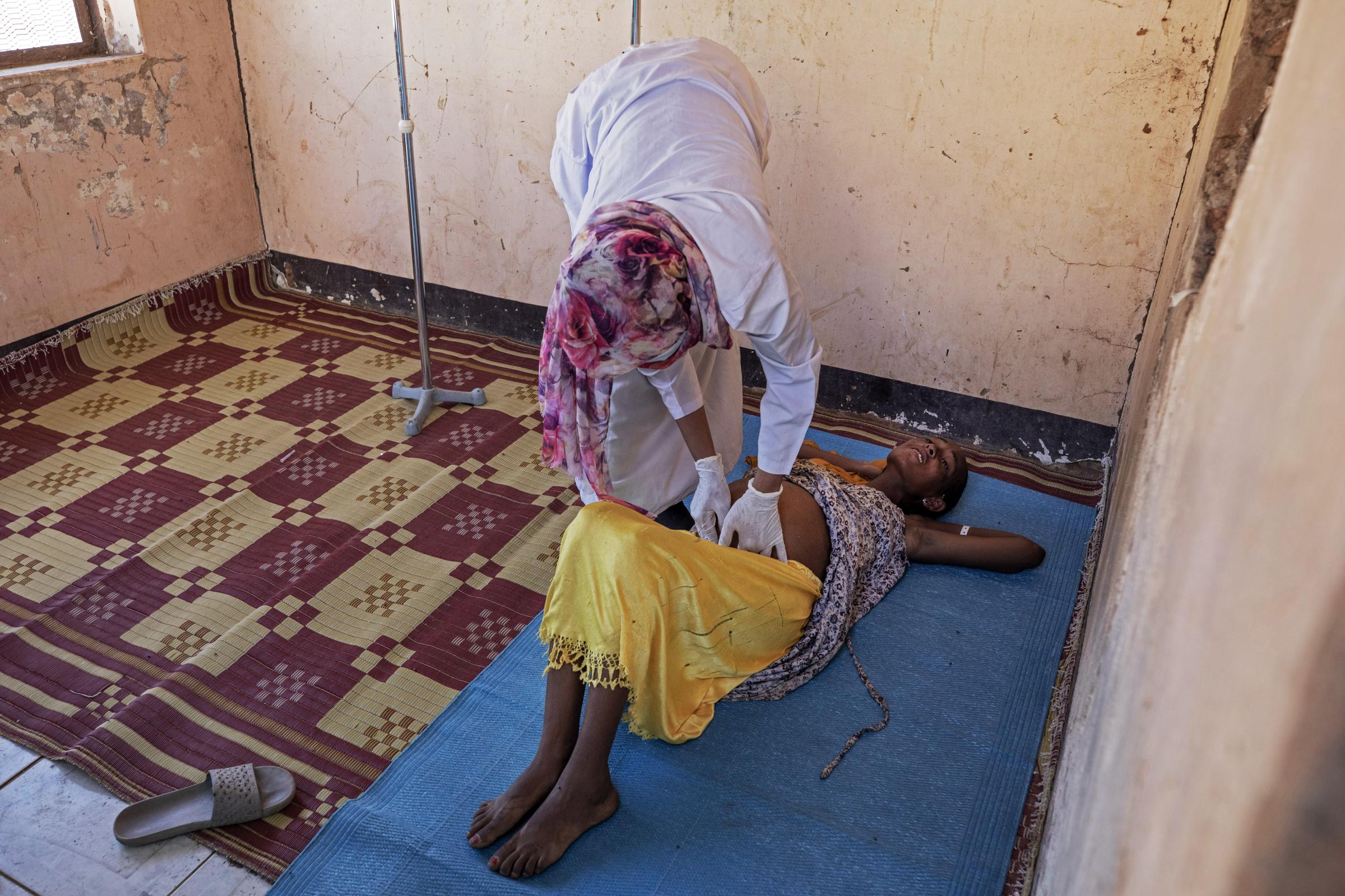A Sudanese midwife checks a malnourished 9-month pregnant woman inside the Mercy Corps clinic at Umm Rakouba refugee camp.