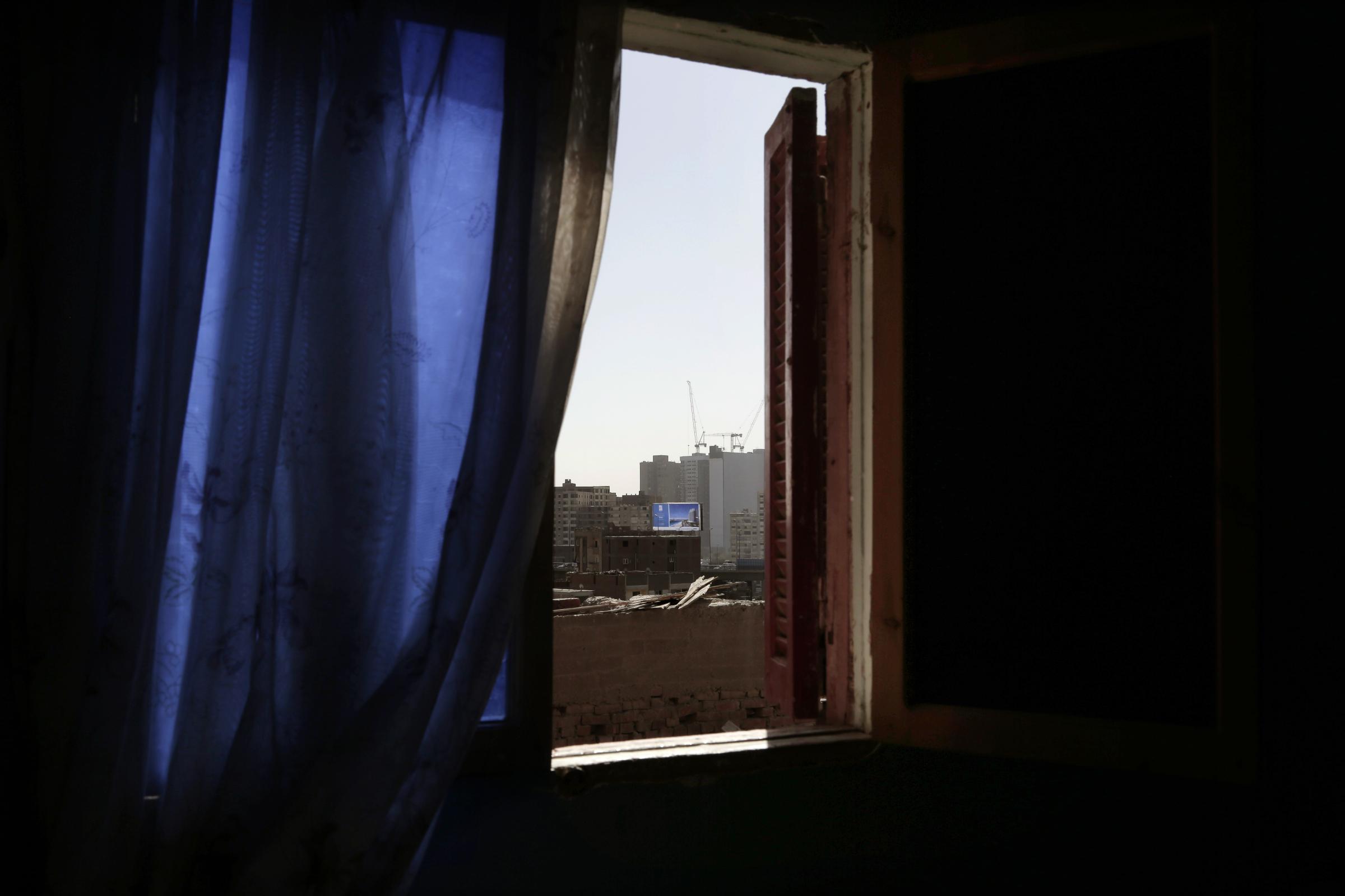  The view from a bedroom window in slum area includes a billboard advertising a pricey gated suburban compound in Ezbet Khairallah. 