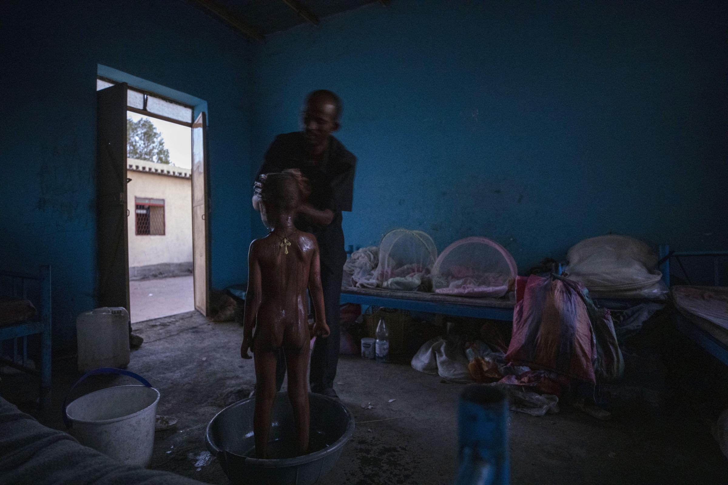  Abraha Kinfe bathes his 5-year-old son, Micheale, in their shelter in Hamdayet. 