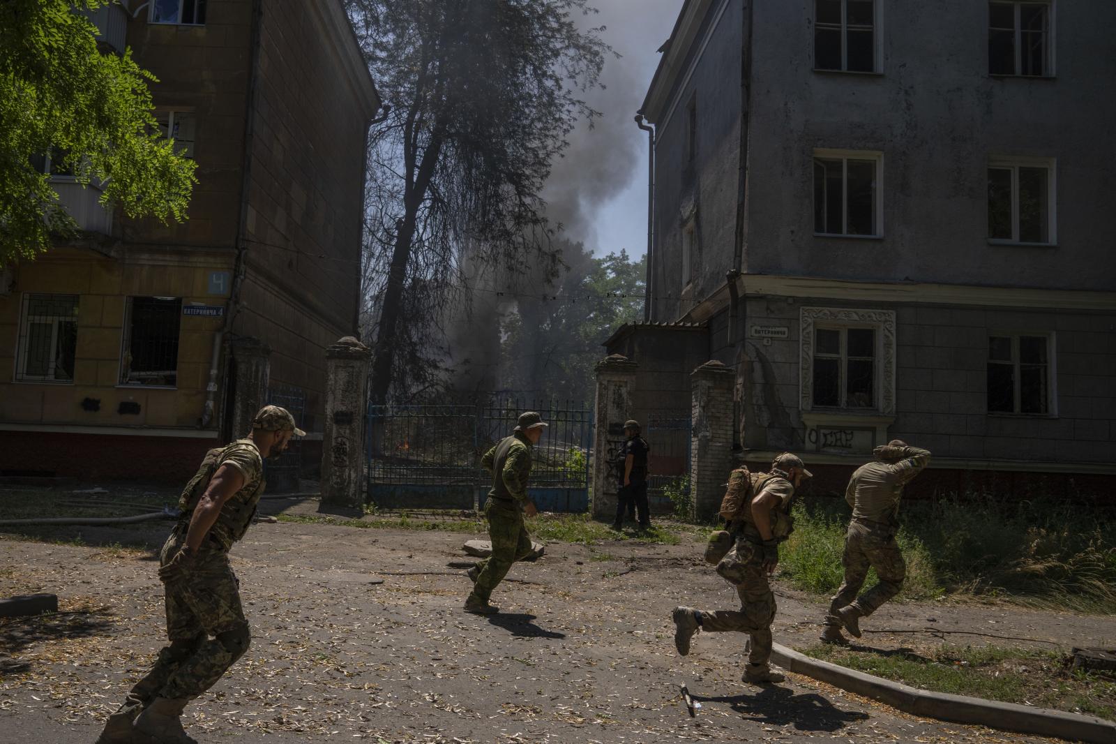  Ukrainian soldiers run after a...sidential area, in Kramatorsk. 