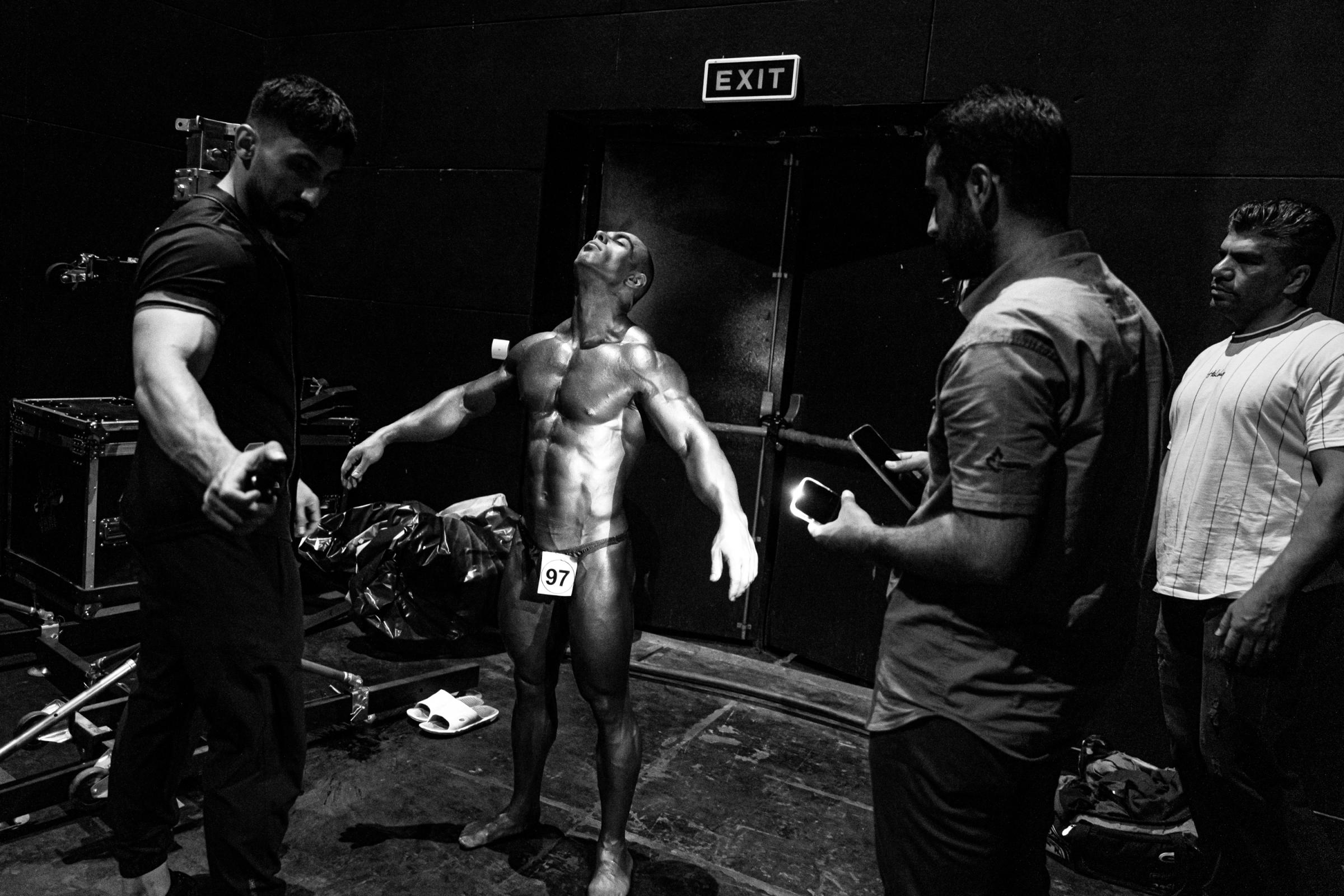 Backstage -  Khani sprays his body with paint for the last time by...