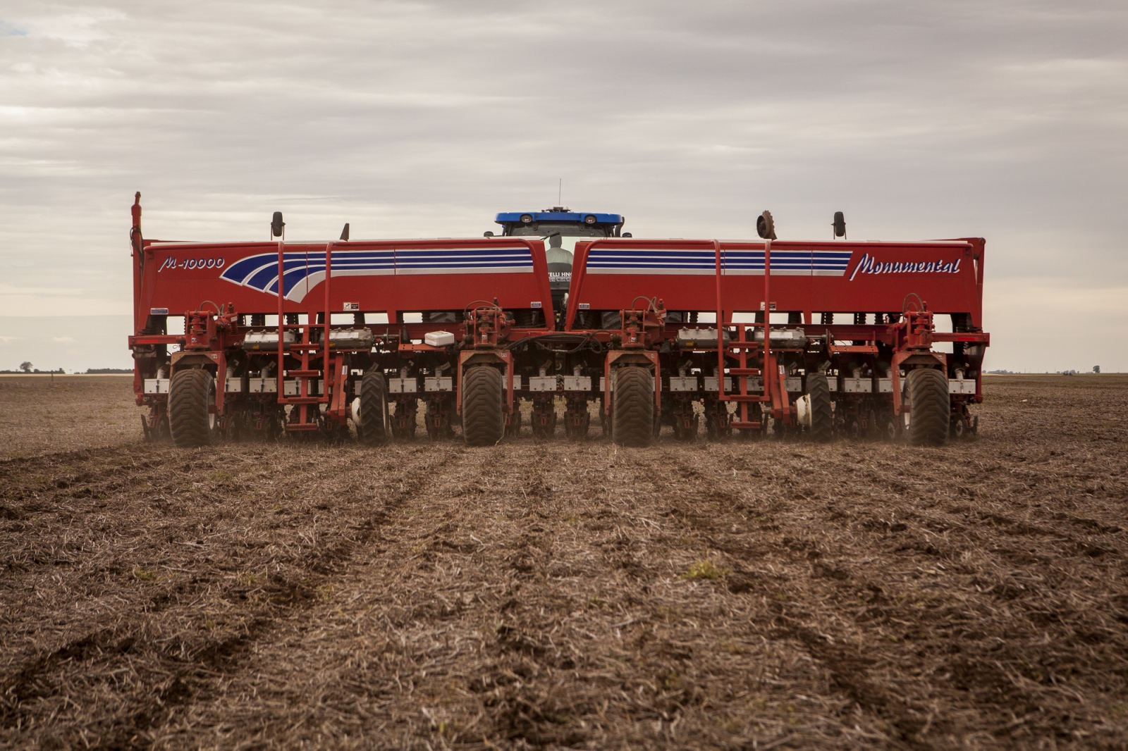 A seeding machine seen from behind is dropping soy seeds on a field in the Monte Maiz region. 22...