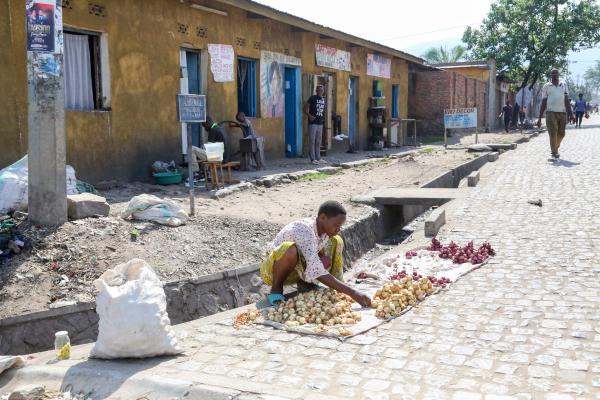 Bujumbura - City in the Heart of Africa - A woman finds a spot on the curb to sell onions in the Kamenge neighborhood. Food is often...