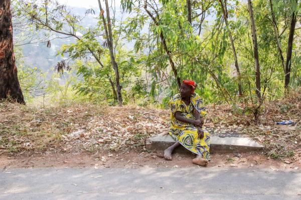 Bujumbura - City in the Heart of Africa - A woman sits on the side of the road on a hill that leads to Belvediere Hill. Lack of government...