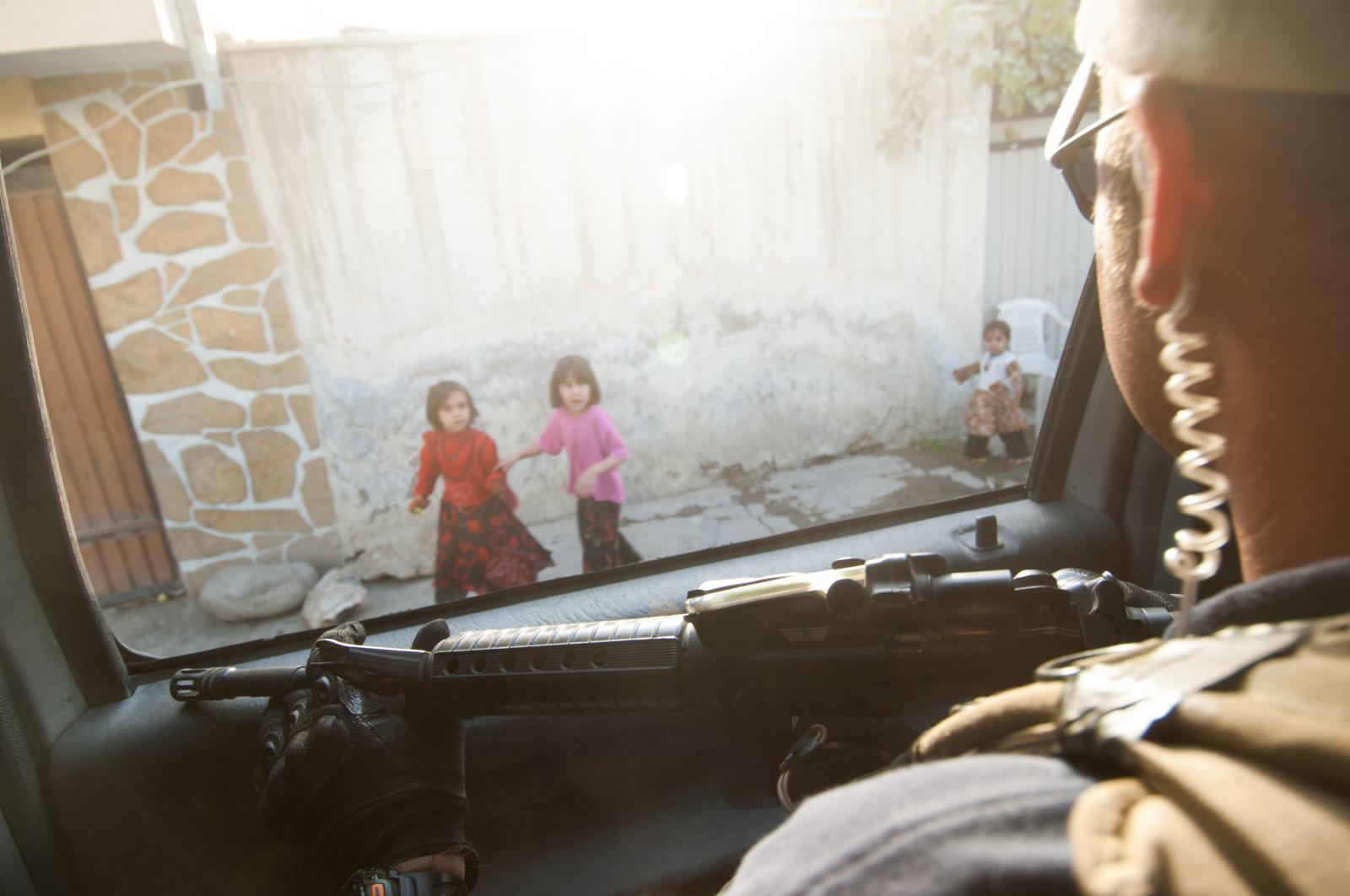 Young Afghan children look on a... oversight from any government.