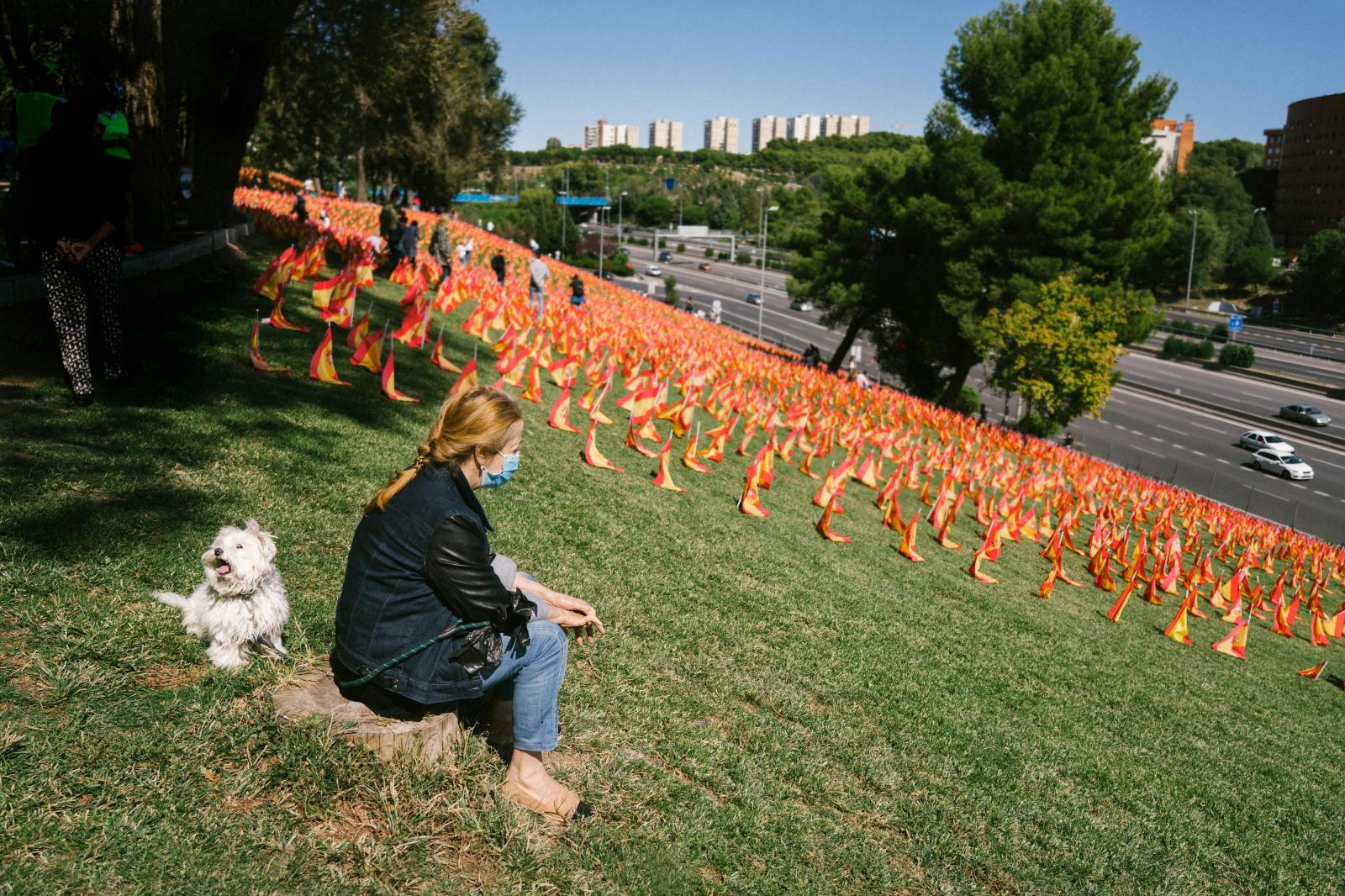Overview - A woman sits next to the tribute to the victims of...