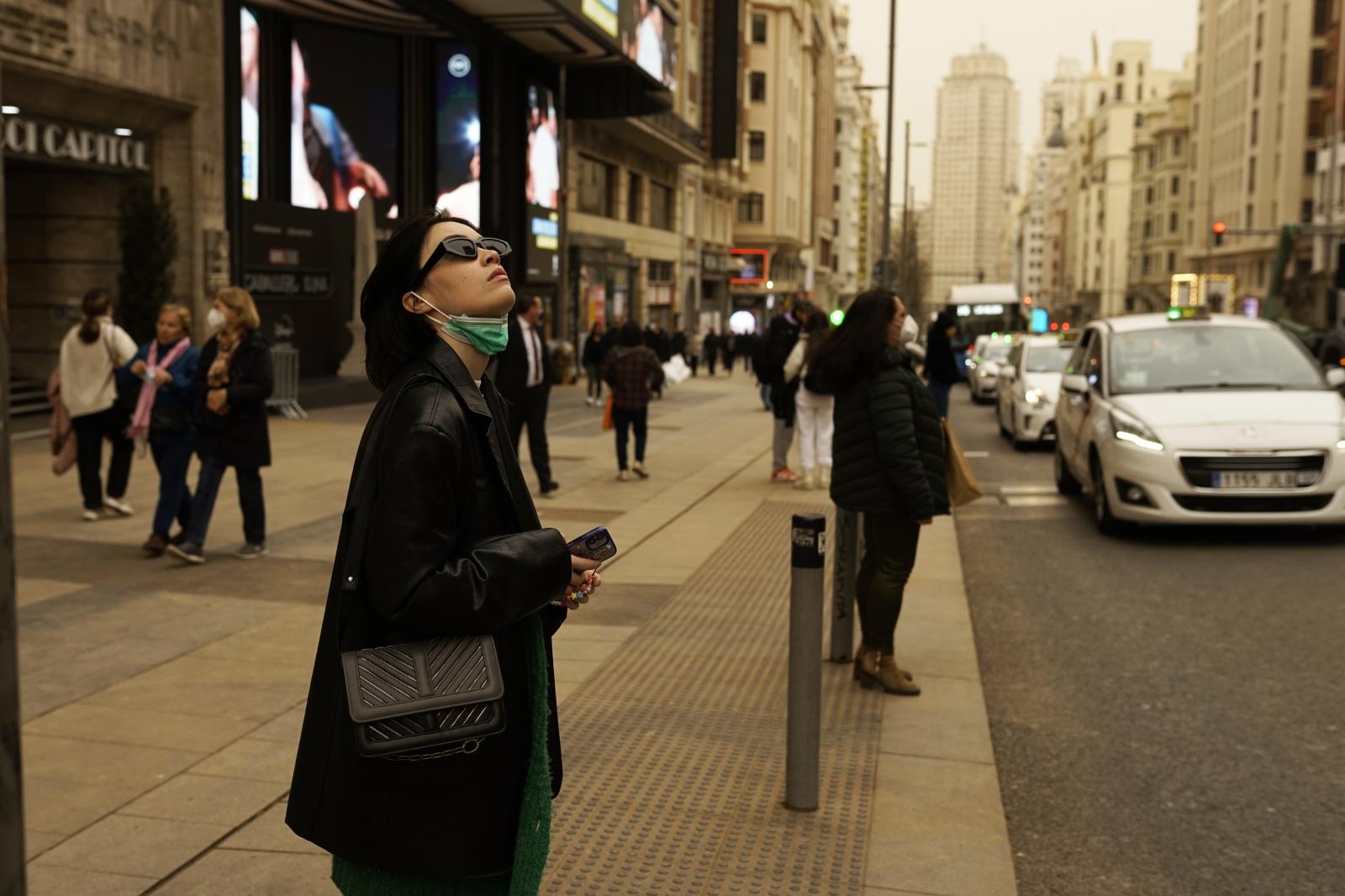 Image from Overview - A woman observes the sky over Madrid on Gran Vía....