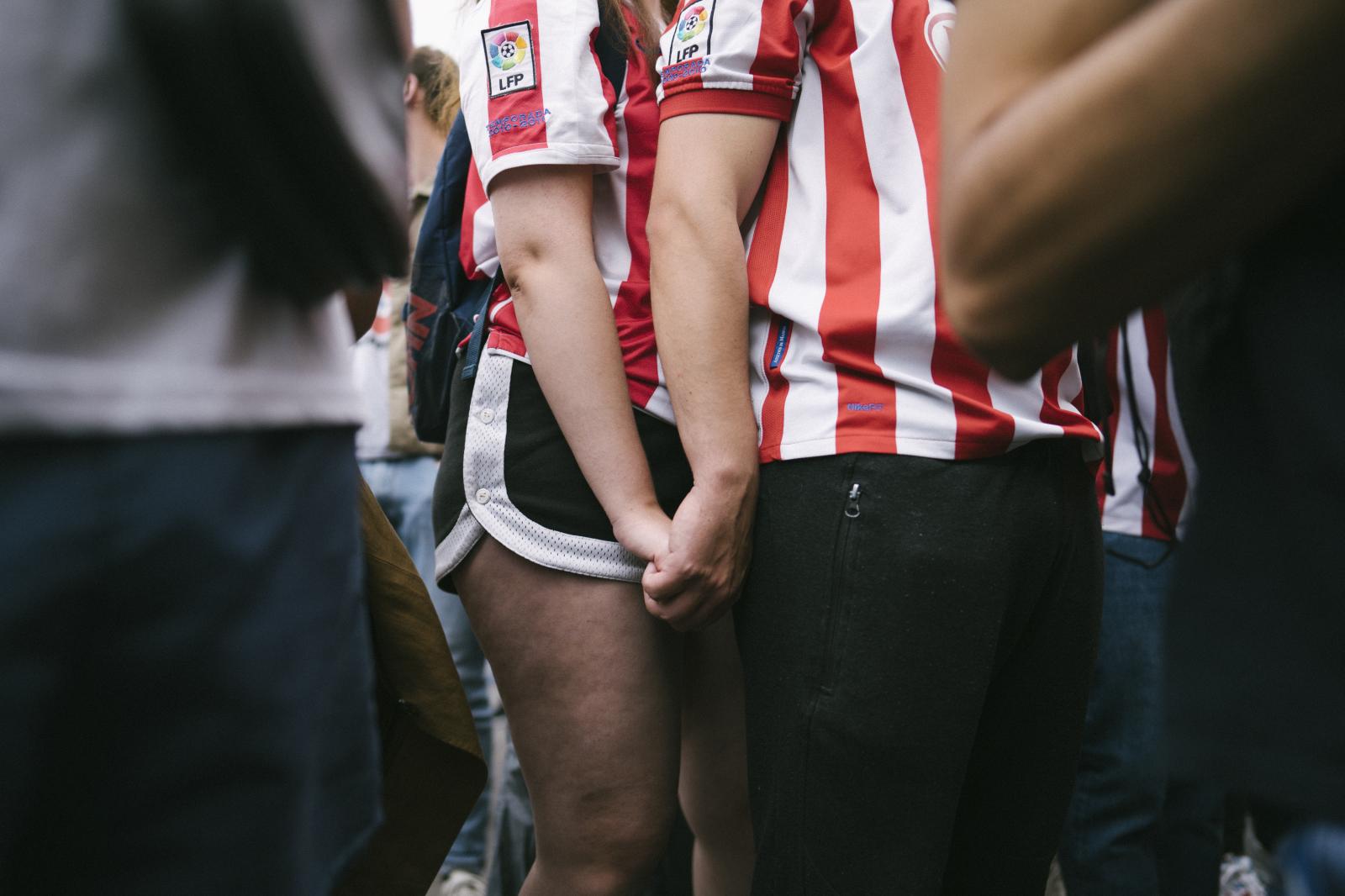 Overview - Two Atletico de Madrid fans hold hands during the Spanish...