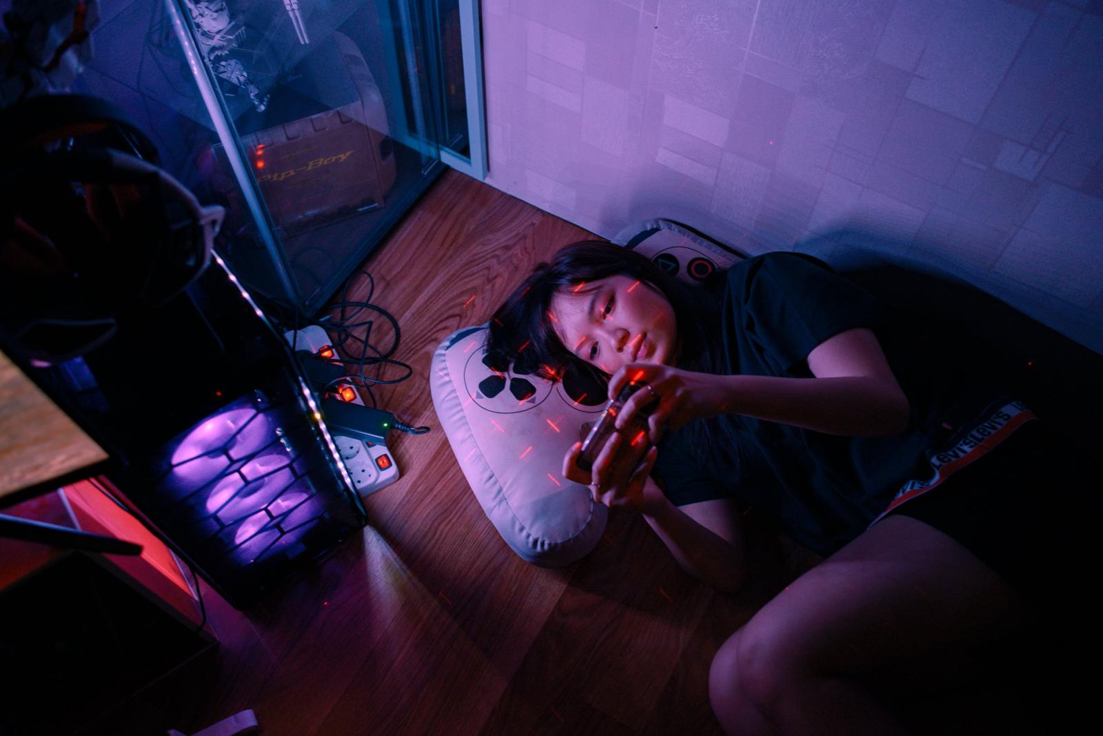 Virtual Insanity: Inside The Life of Pro-Gamers - Nixia laying around while keep gaming with smartphone. She is also expert using various type of...