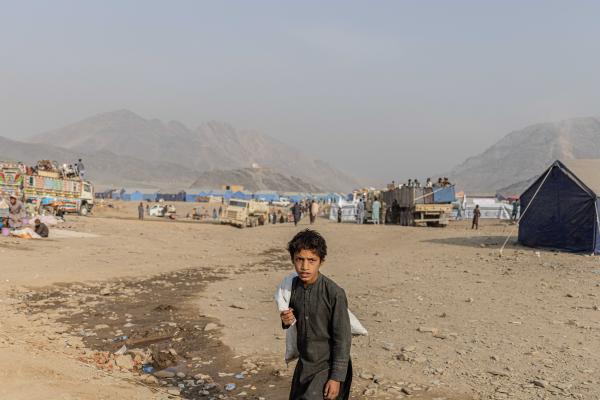 Contrasting Childhoods Joyful Play vs Hardship - Abdulaziz, a 13-year-old recently expelled from Pakistan, searches for plastic along the...