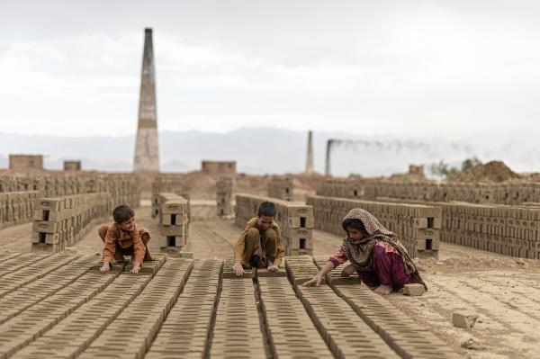 Contrasting Childhoods Joyful Play vs Hardship - Due to economic hardships, many children are forced to work alongside their parents in brick...