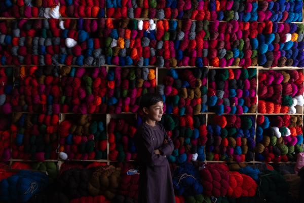 Contrasting Childhoods Joyful Play vs Hardship - A child who works in a yarn shop Baharak district-Badakhshan-Afghanistan  