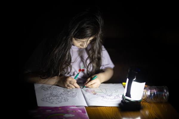 Contrasting Childhoods Joyful Play vs Hardship - My daughter is painting by the light of a lantern on a night without electricity. &nbsp;...