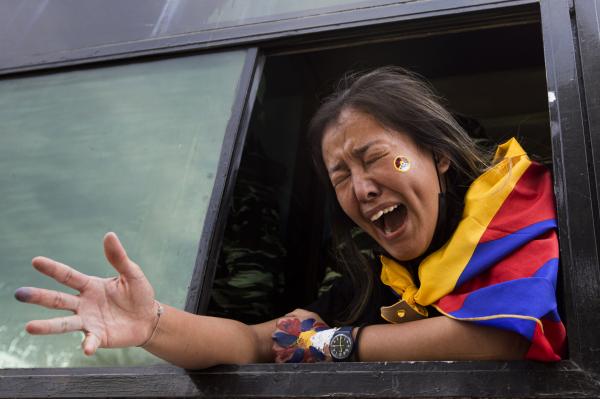 Image from News Coverage - A protester shouts slogans from inside a bus after being...