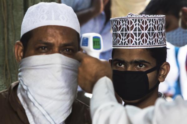 India's Covid-19 pandemic - A Muslim man gets his body temperature checked as he...