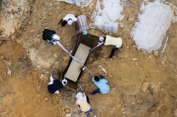 Image from India's Covid-19 pandemic - In this aerial picture graveyard workers and relatives...