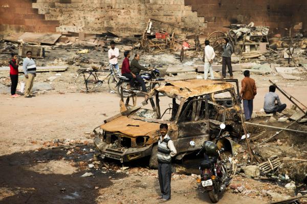 News Coverage - Residents look at burnt-out vehicles following sectarian...