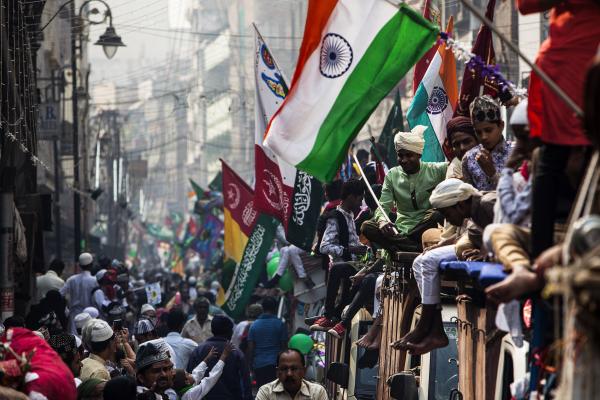 Image from Religion and Festivals - Indian Muslim devotees wave flags as they parade atop...