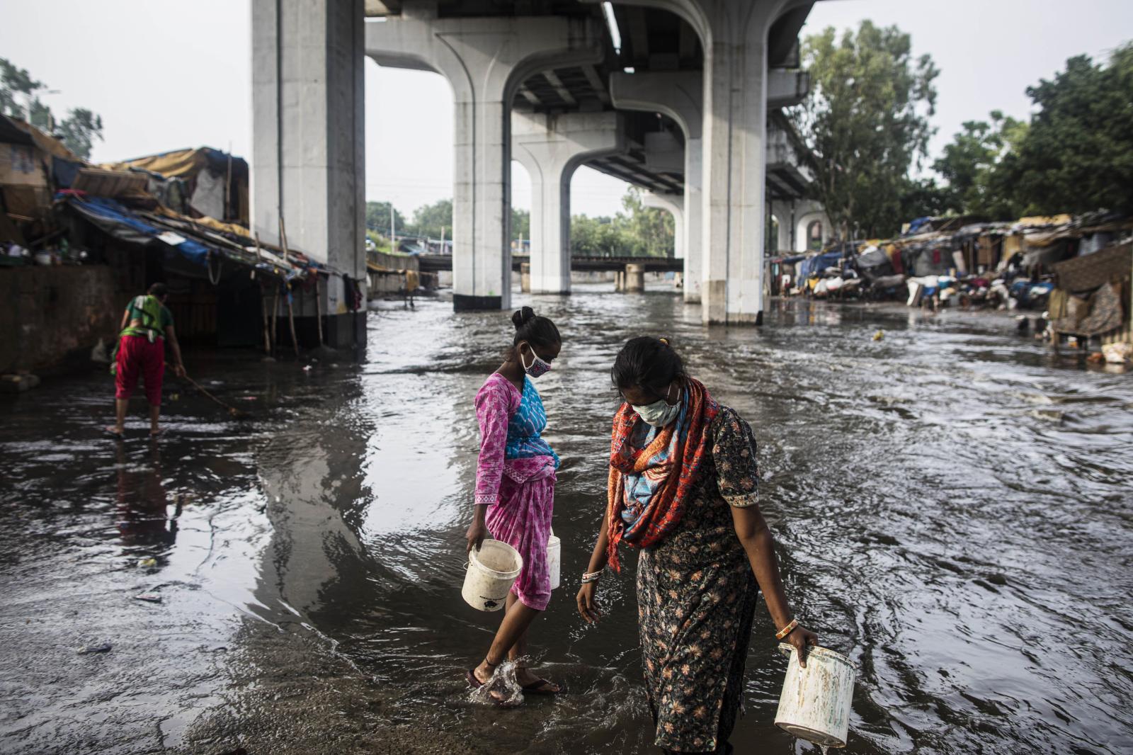 Residents of a slum area fill b... GALIANA / AFP) New Delhi India