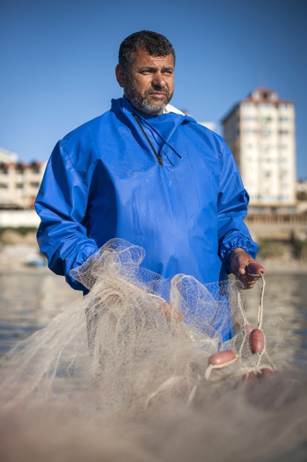  47 year old Gaza Fisherman Nasser Abu Emeira checking his fishing nets while in Gaza Port, Gaza Strip, occupied Palestinian territories. 